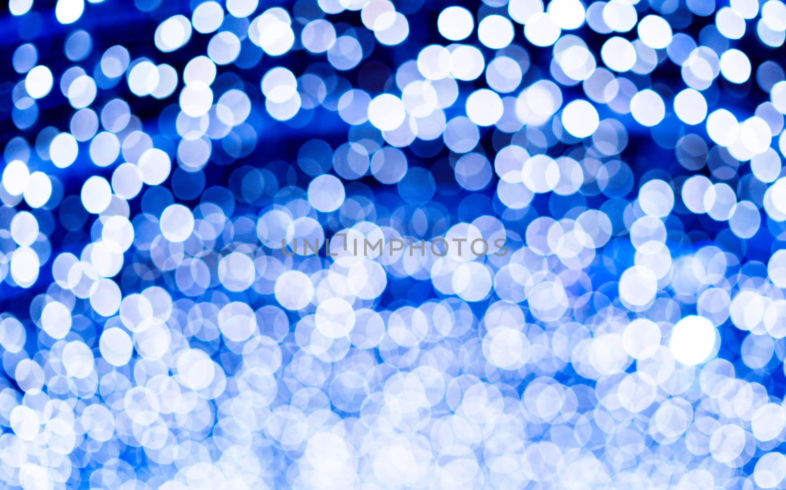 Blue beautiful blurred bokeh background with copy space. Glitter yellow light spots defocused by tanaonte