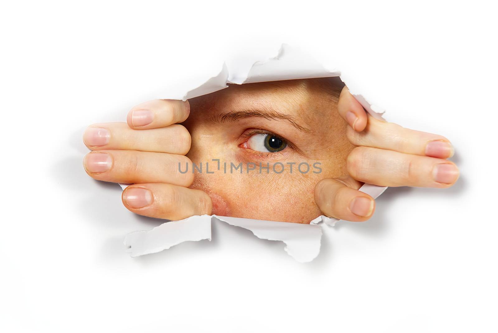 Young woman peeping through hole on paper. Female Eye looking through hole. Isolated on white background. Spy concept.