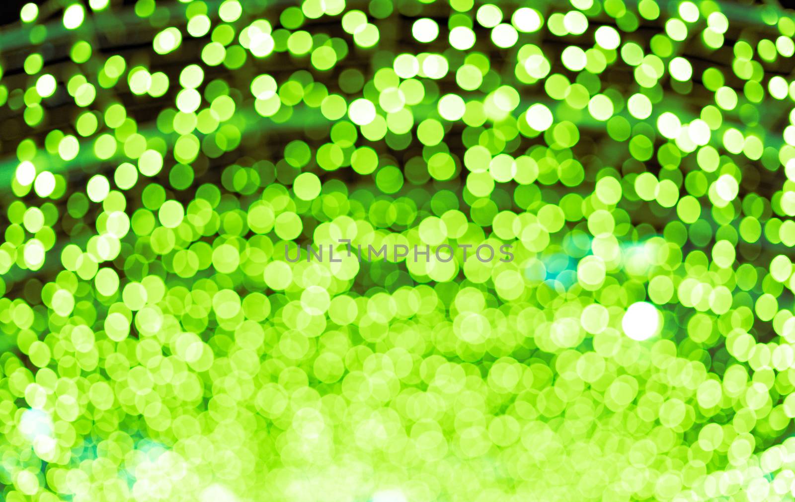 Green beautiful blurred bokeh background with copy space. Glitter yellow light spots defocused by tanaonte