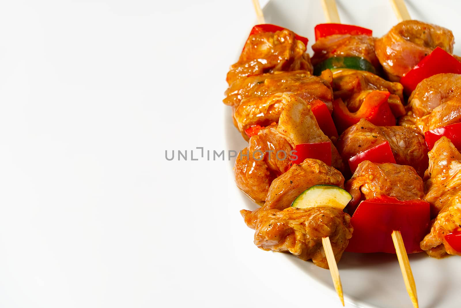raw marinated chicken meat on wooden skewers, pork, chicken, beef in white plate on white background. by PhotoTime