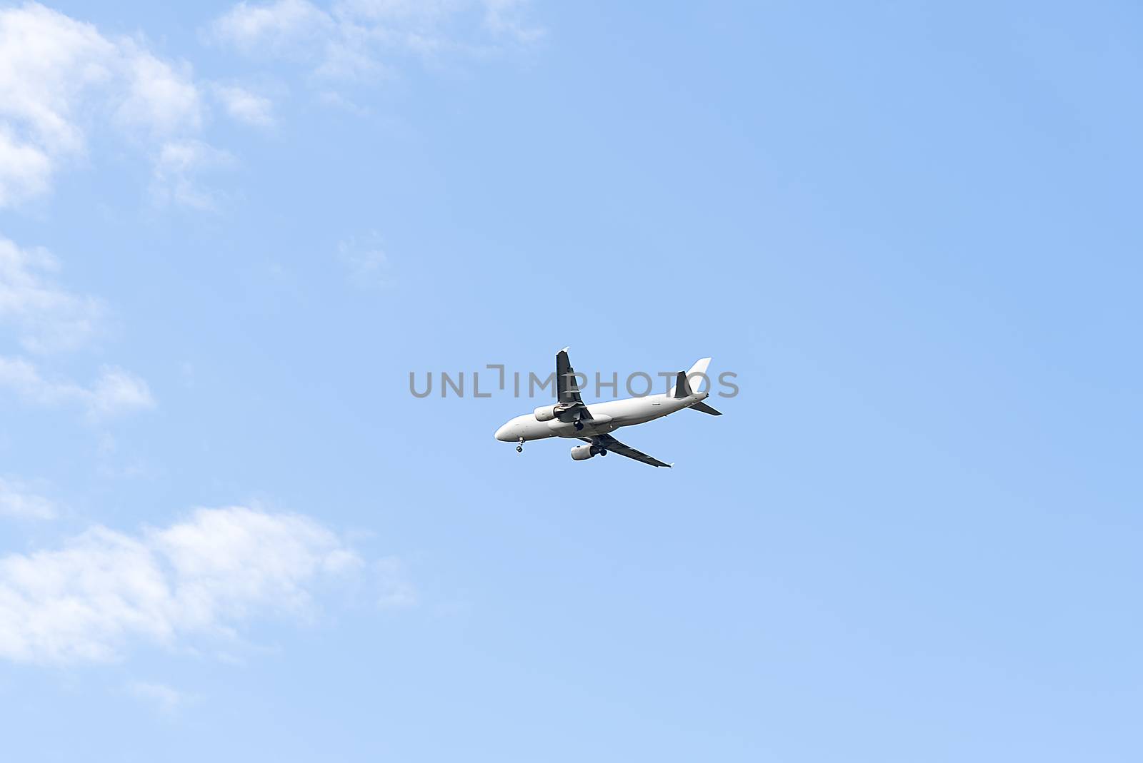 Jet plane flying in blue sky, preparing for landing