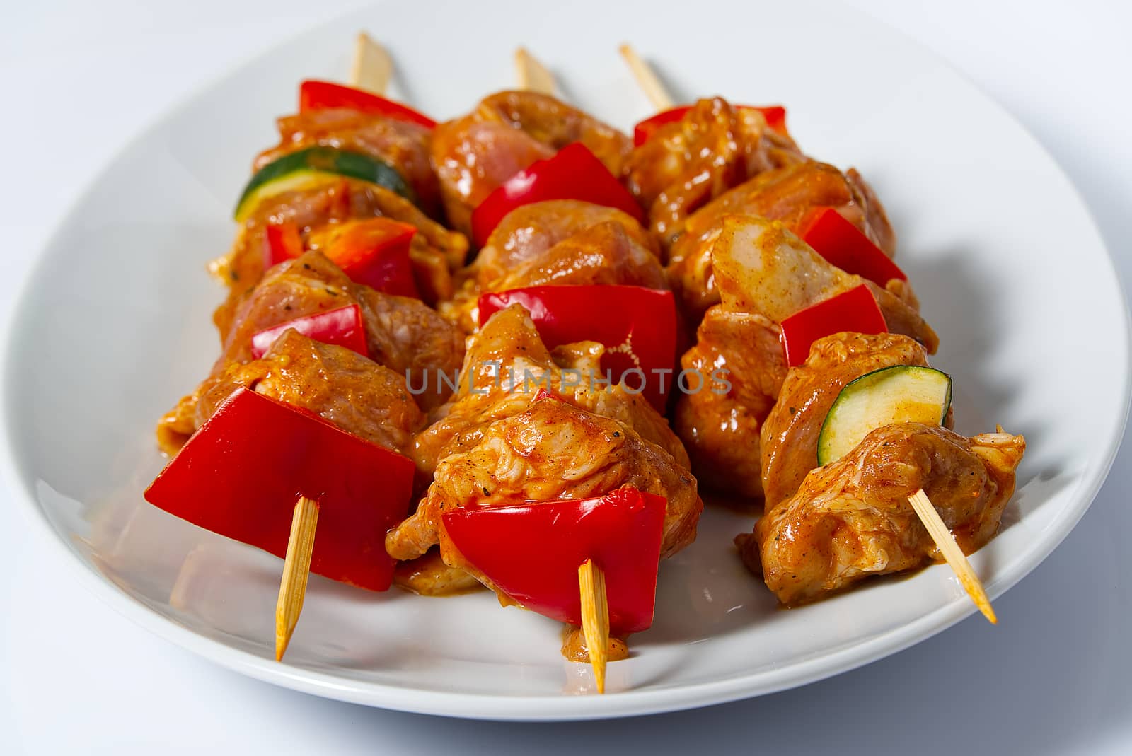 raw marinated chicken meat on wooden skewers, pork, chicken, beef in white plate on white background. by PhotoTime