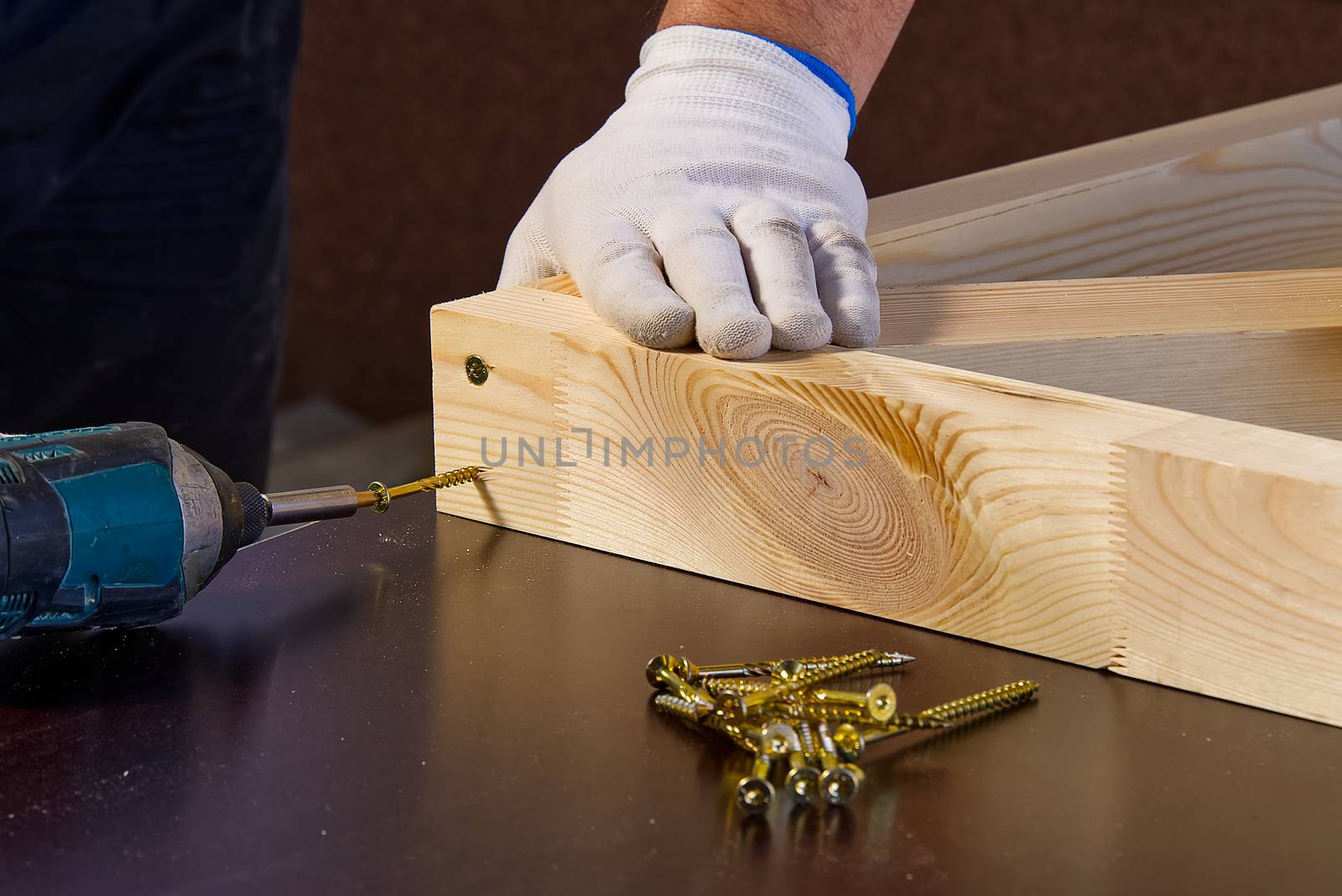Closeup of professional cabinet makers working with electric circular saw at woodworking workshop. Wood material production. Lumber factory by PhotoTime