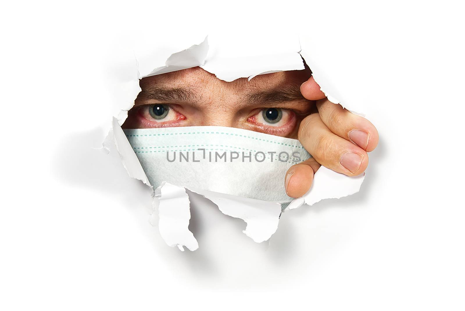 Man in medical mask peeping through hole on paper. Male Eye looking through hole. Isolated on white background. covid - 19 concept, coronavirus.