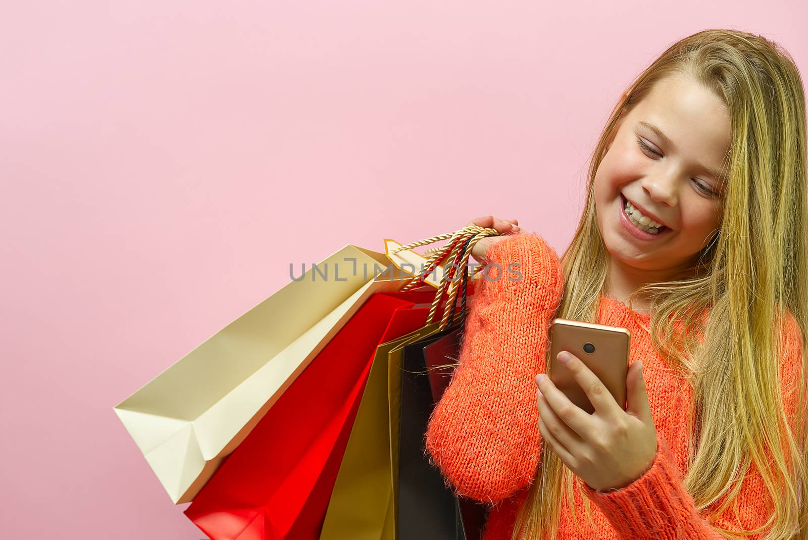 Girl hand holding modern mobile phone for online shopping. white screen on a screen. Online shopping concept with smartphone. girl on pink background