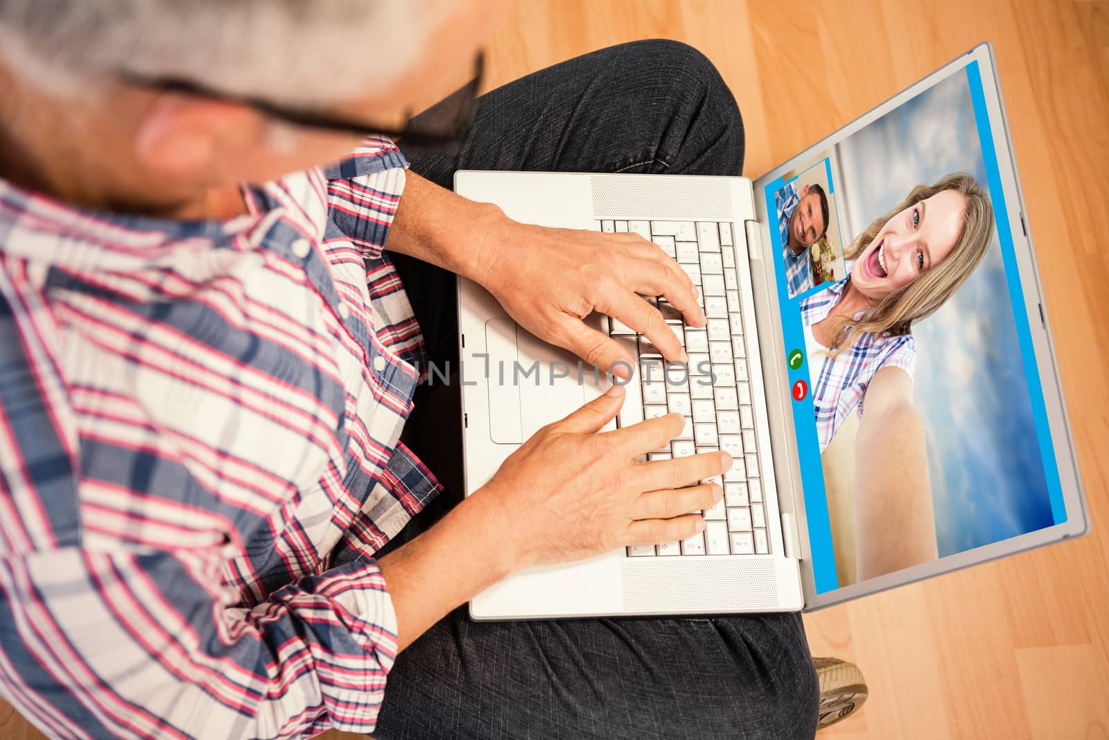 Happy hipster smiling at camera  against man using laptop while sitting on floor at home