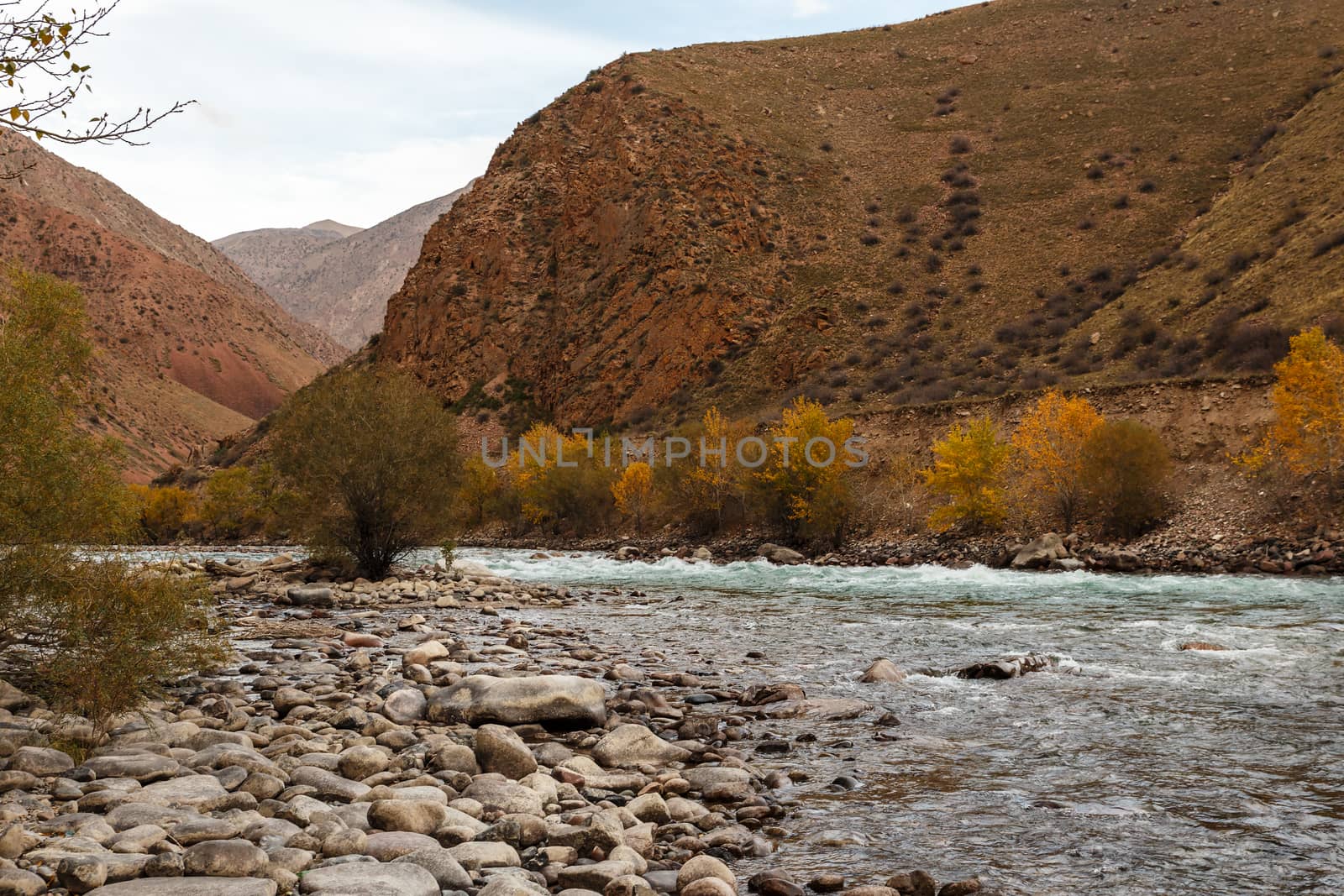 The rocky shore of a mountain river. Kokemeren river is a right tributary of Naryn River located in Jumgal District of Naryn Province of Kyrgyzstan.