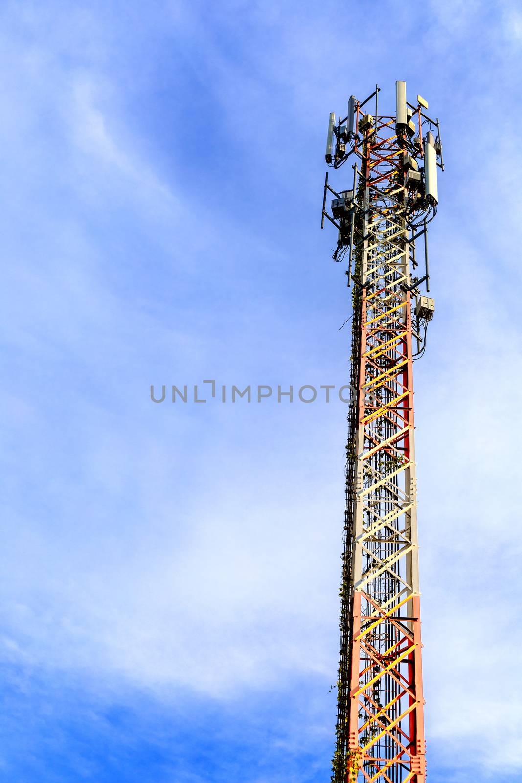 mobile phone communication and network signal repeater antenna tower with blue sky background