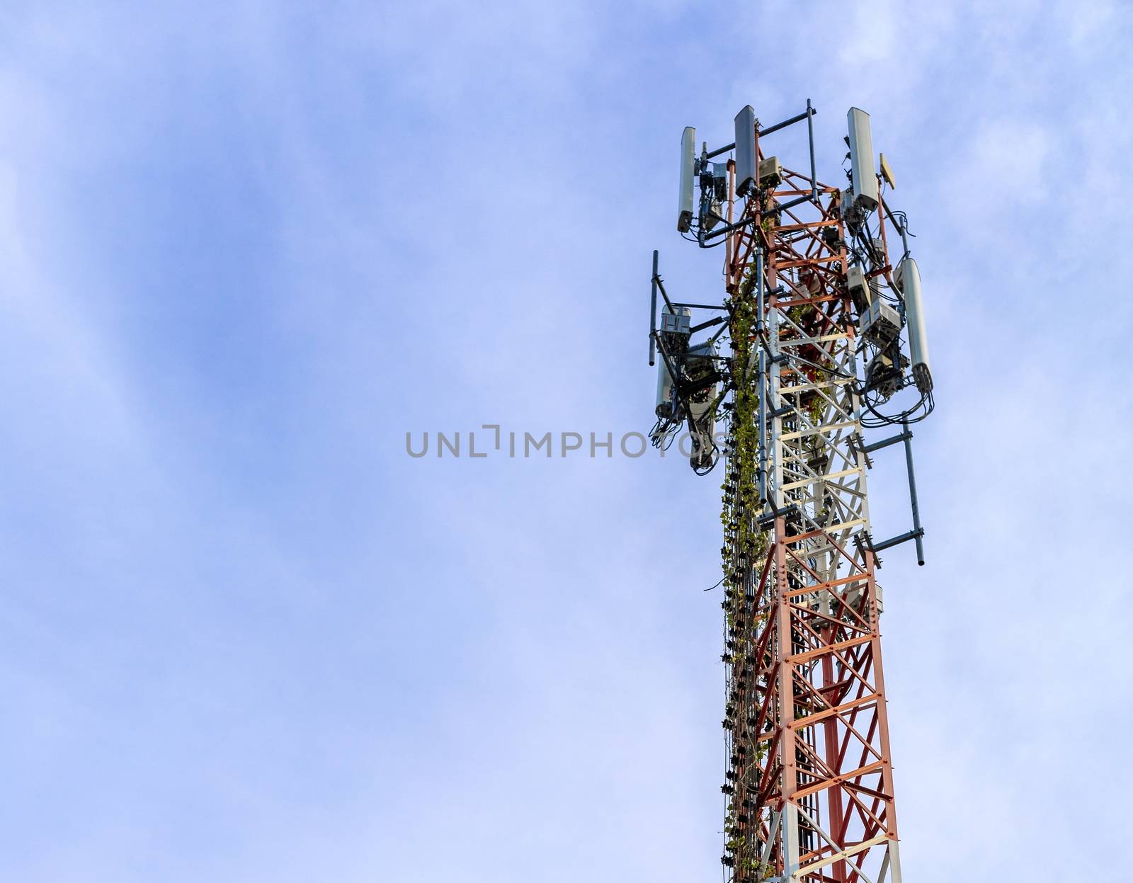 mobile phone communication and network signal repeater antenna tower with blue sky background