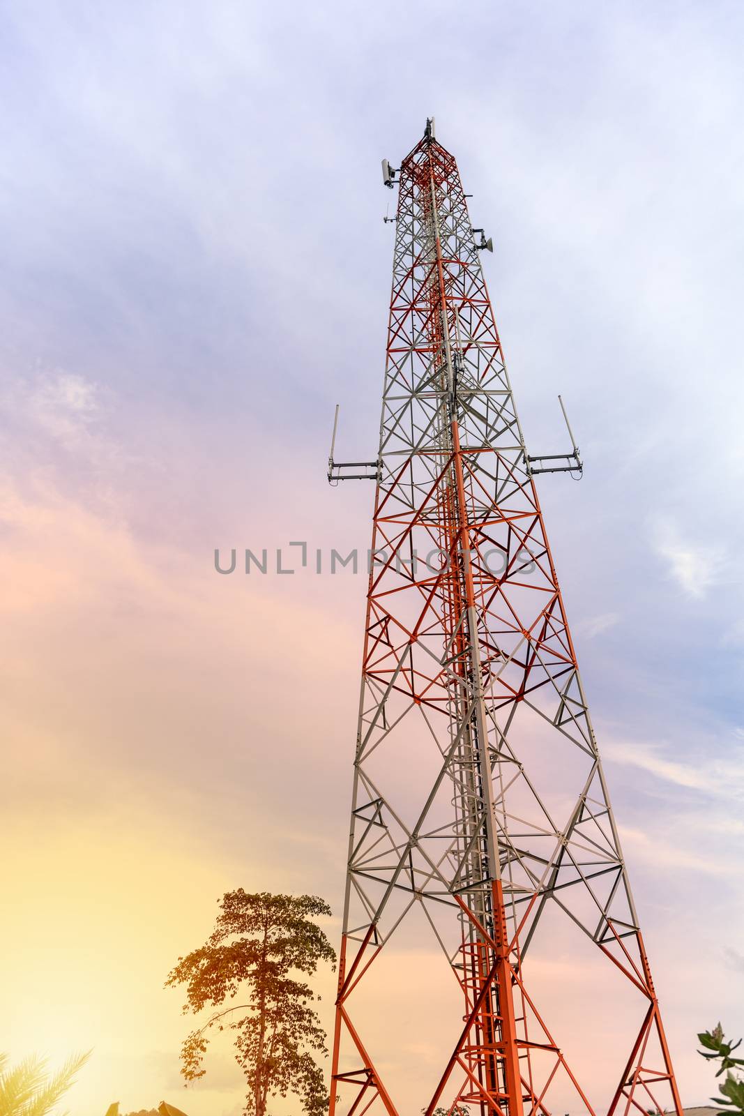 mobile phone communication and network signal repeater antenna tower with blue sky background. Sun light effect.