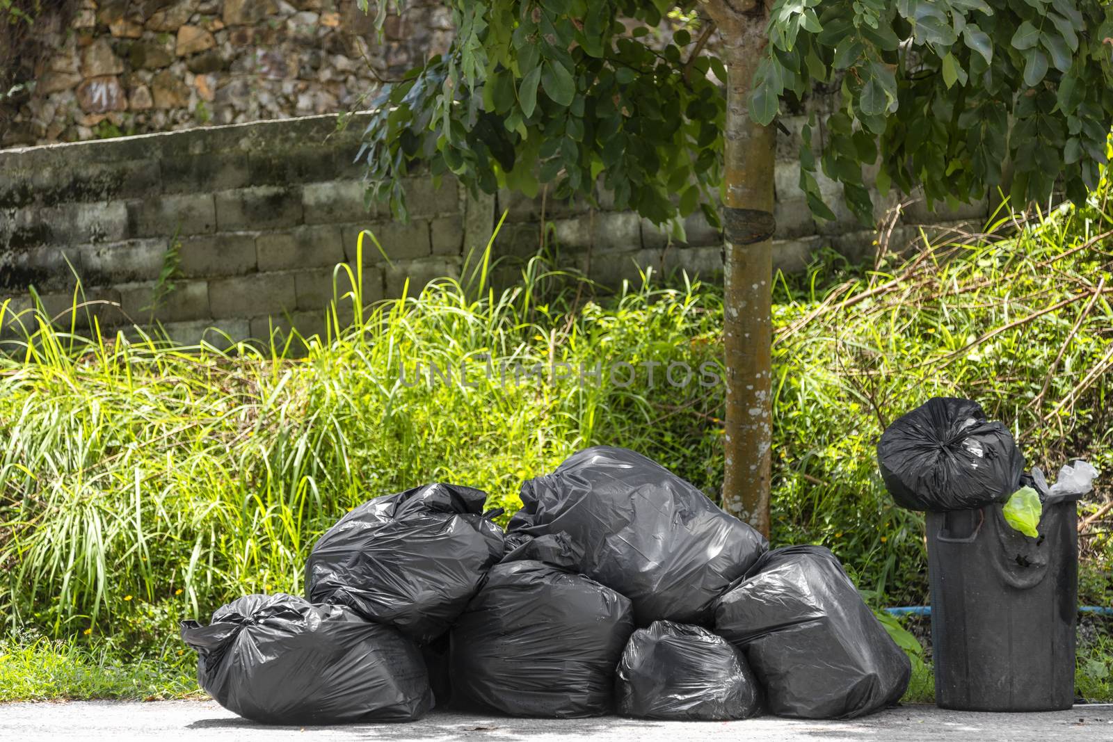 Big and many plastic garbage bag on streets with garbage sitting on ground