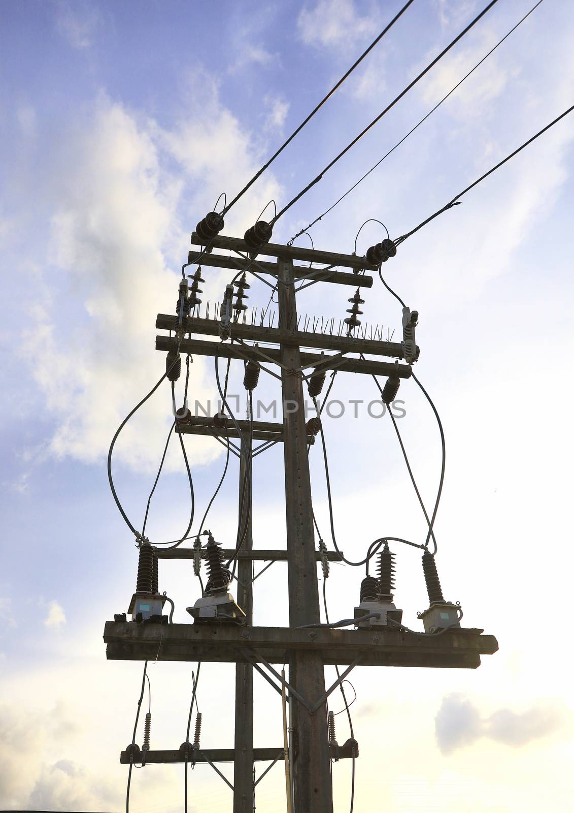 Energy and technology concept. High voltage electricity pole with eletric line and small transformers