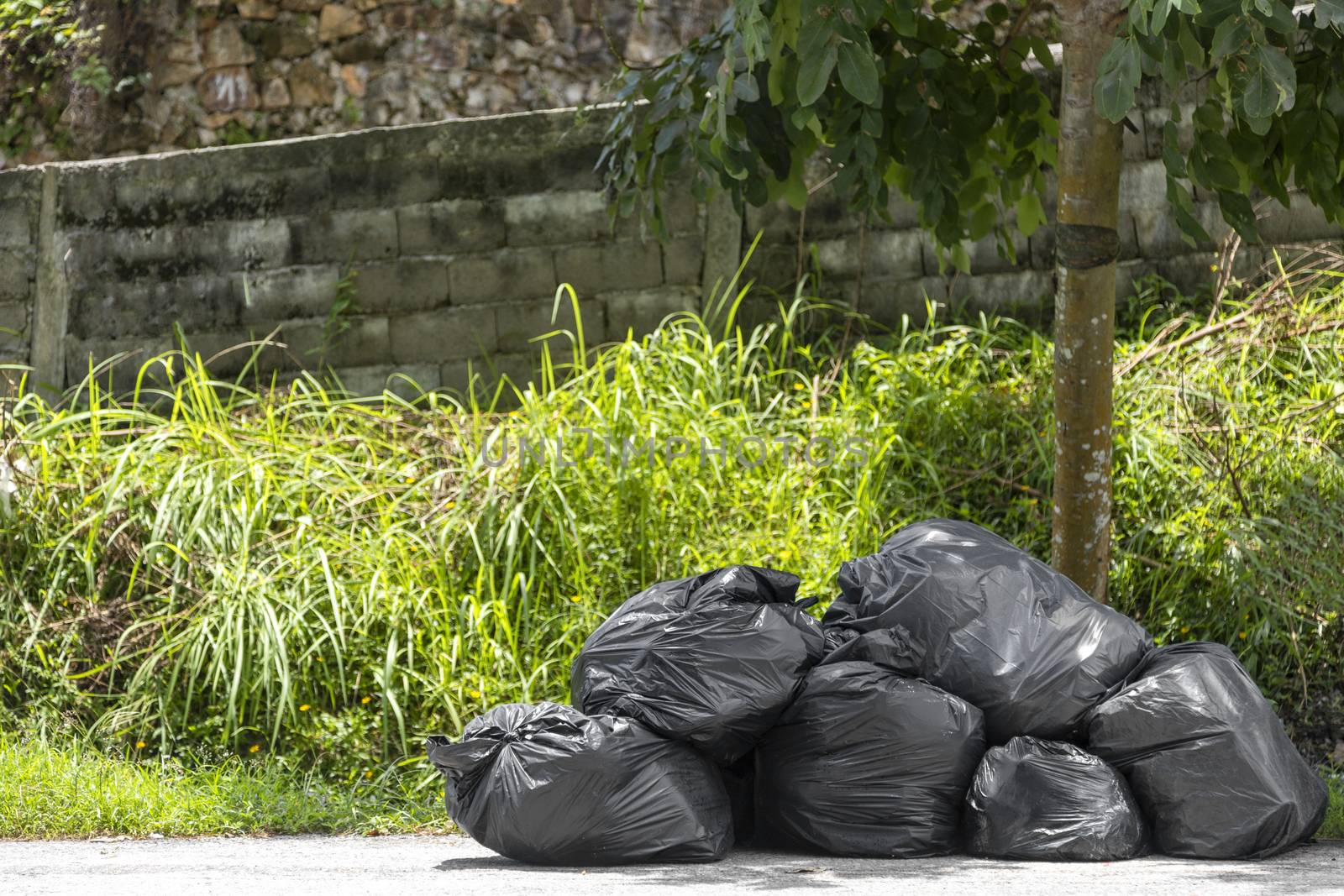 Big and many plastic garbage bag on streets with garbage sitting on ground