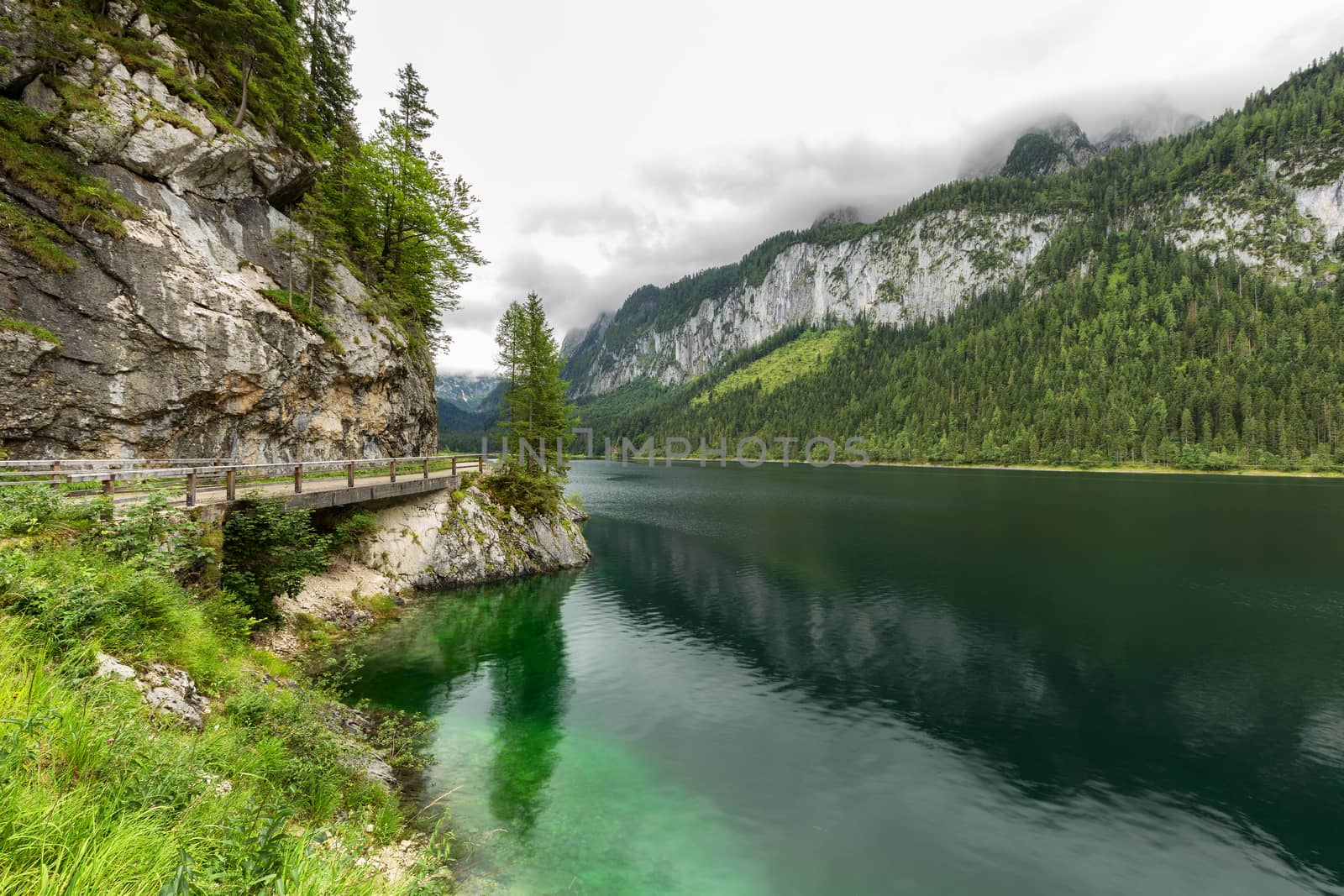 Great azure alpine lake Vorderer Gosausee. Picturesque and gorgeous rain clouds