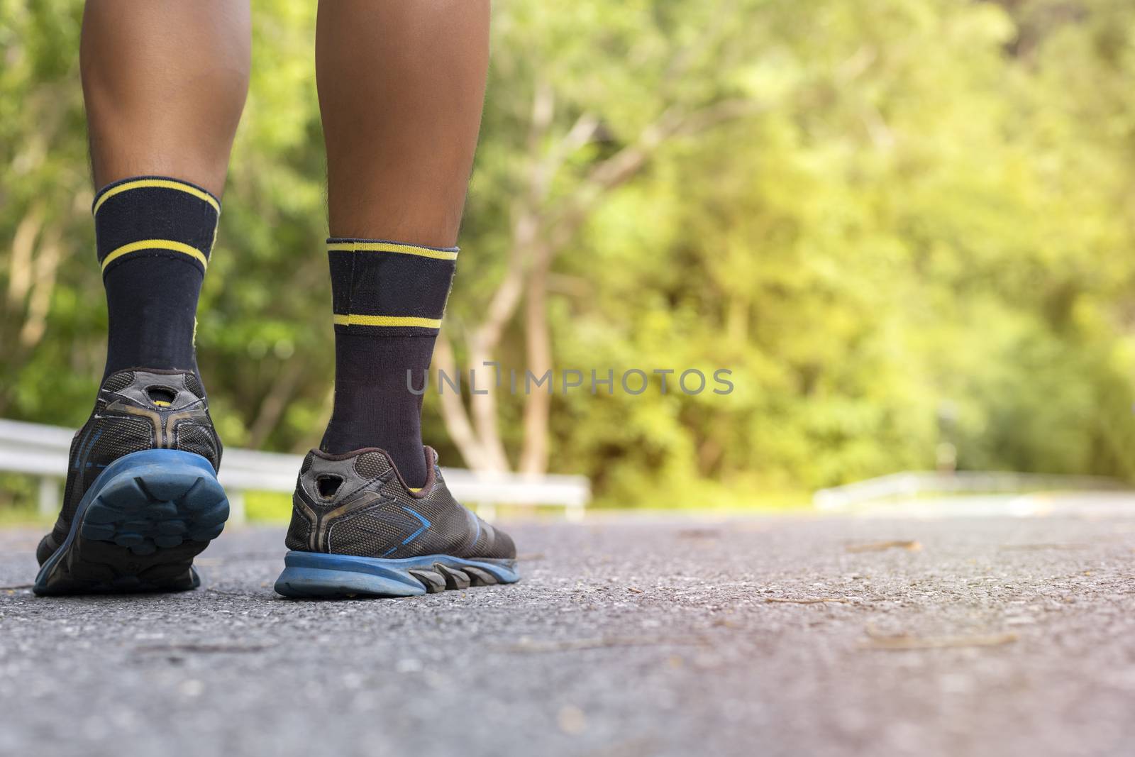 Man runner feet on road in Park workout wellness soft focus and focus close up on shoe 