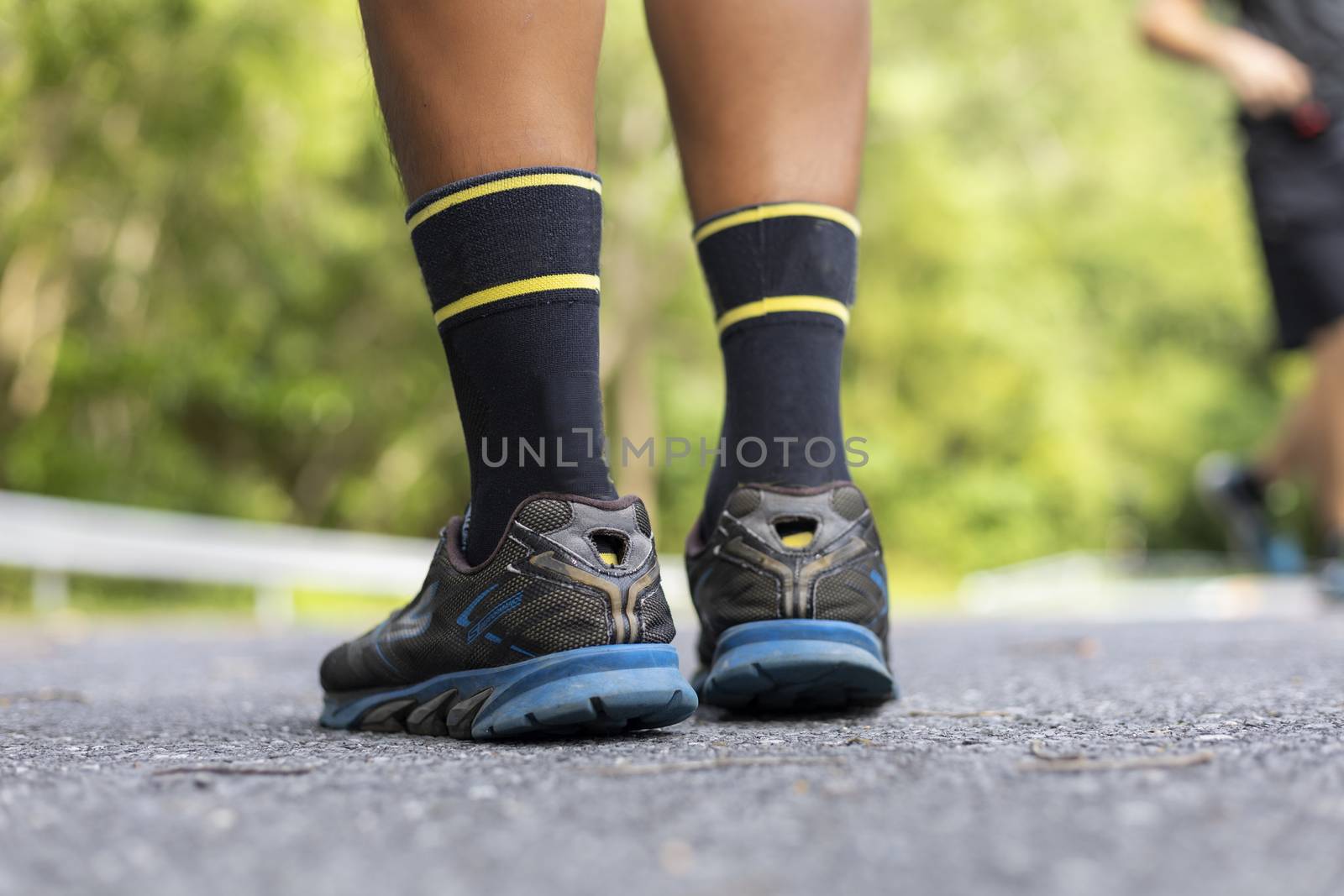 Man runner feet on road in Park workout wellness soft focus and focus close up on shoe 