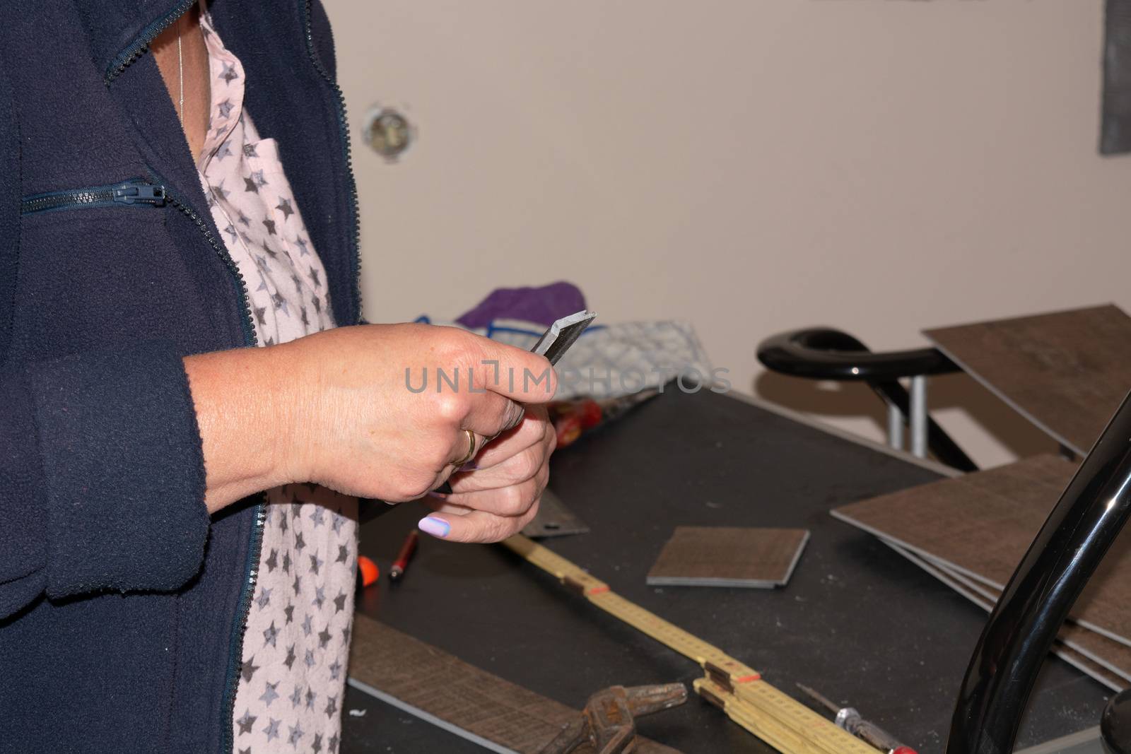 Woman in laying a laminate floor - closeup on female hands.