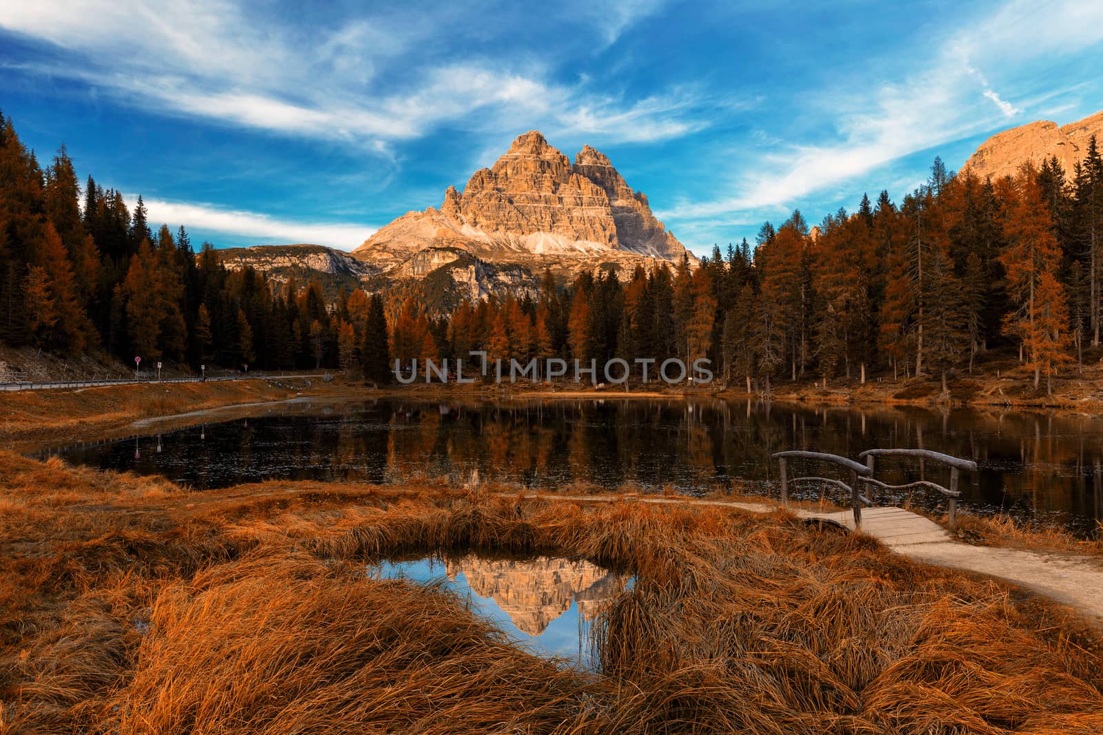 Antorno lake during late autumn with red leaves and tre cime reflection. Italy, Dolomites, Europe