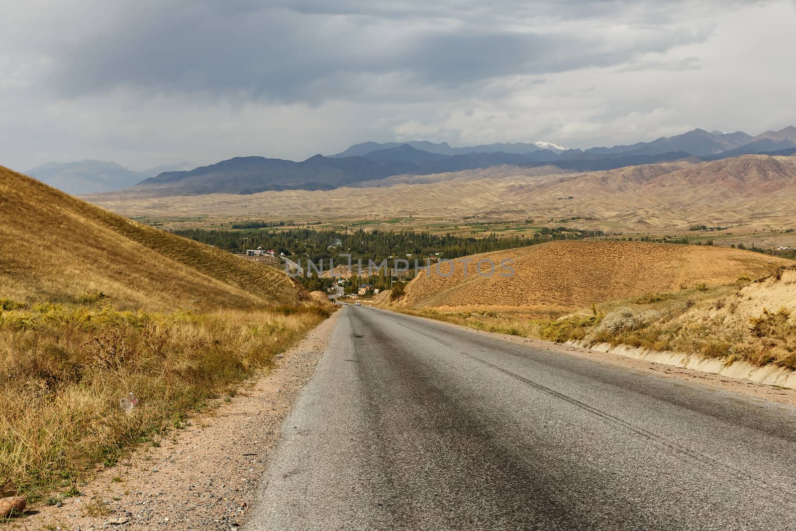 The highway from Bishkek to Osh in front of the Toktogul reservoir in Kyrgyzstan. asphalt road