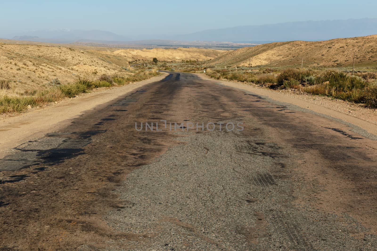 A363 highway, asphalt road along the southern shore of Lake Issyk-Kul in Kyrgyzstan.