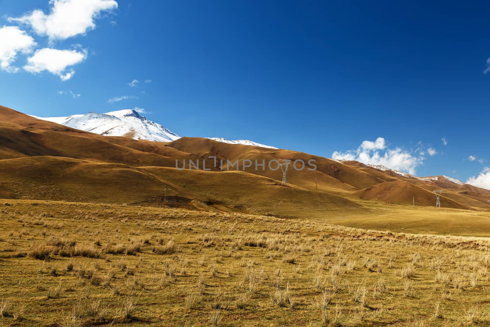 pylons of high-voltage power lines in the mountains, Kochkor District in the Naryn region of Kyrgyzstan. A 367 highway.