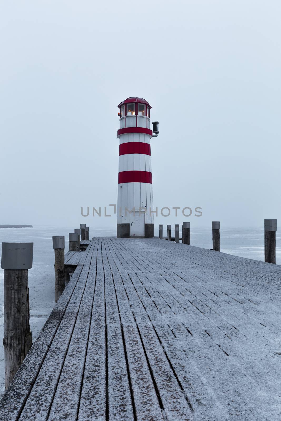 Lighthouse at sunrise with fog and rain during winter by necro79