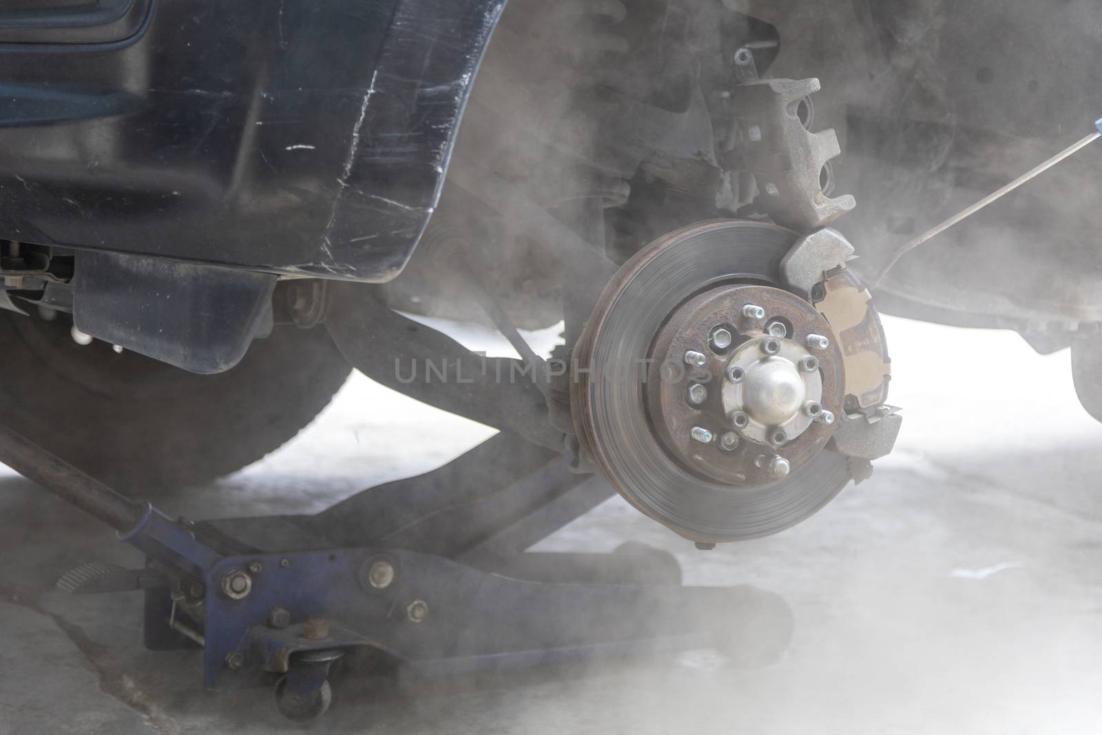Mechanic use air gun clean disc break take dust removes before change break pat.