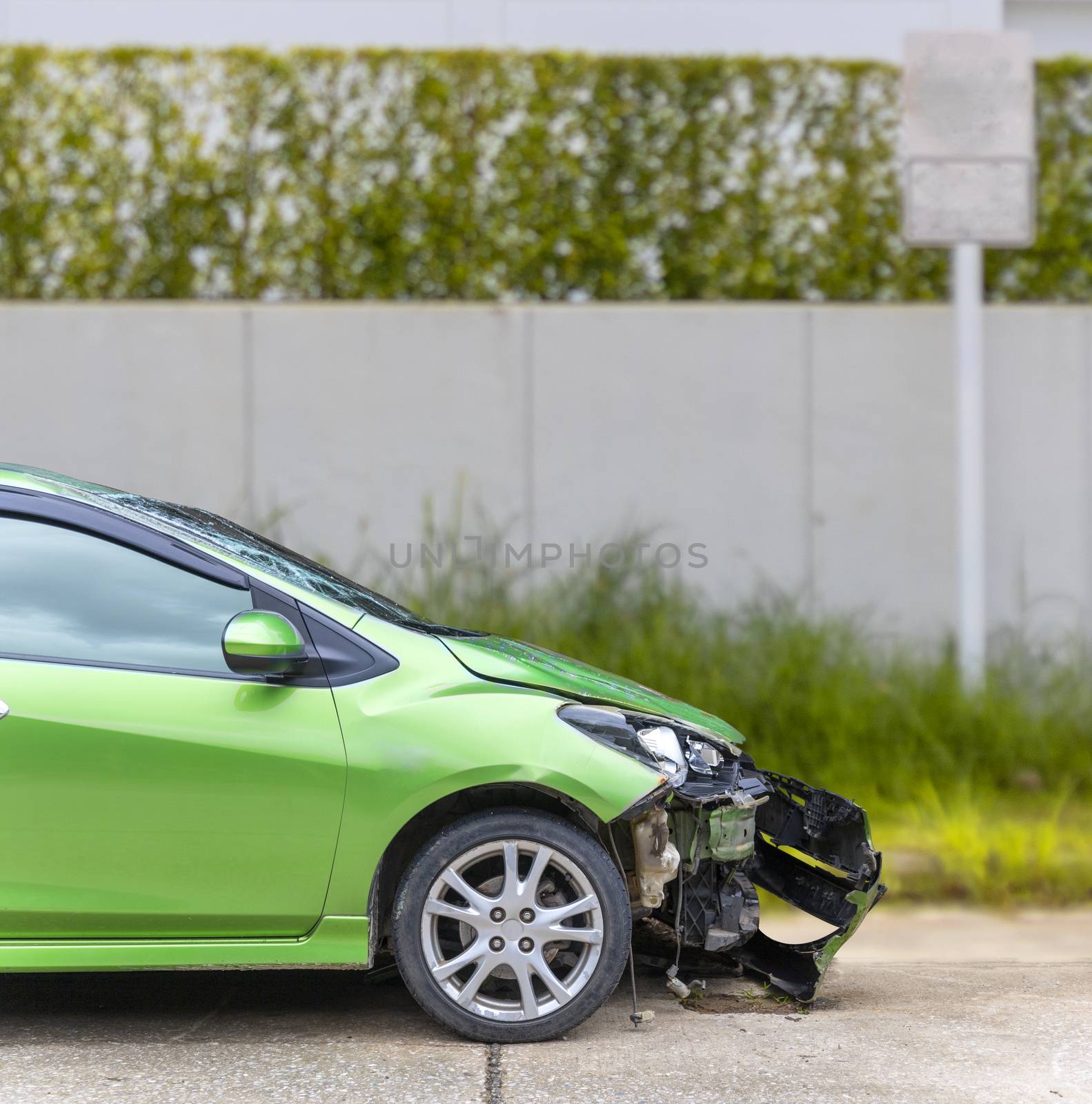Front of green color car damaged and broken by accident on road parking can not dirve any more