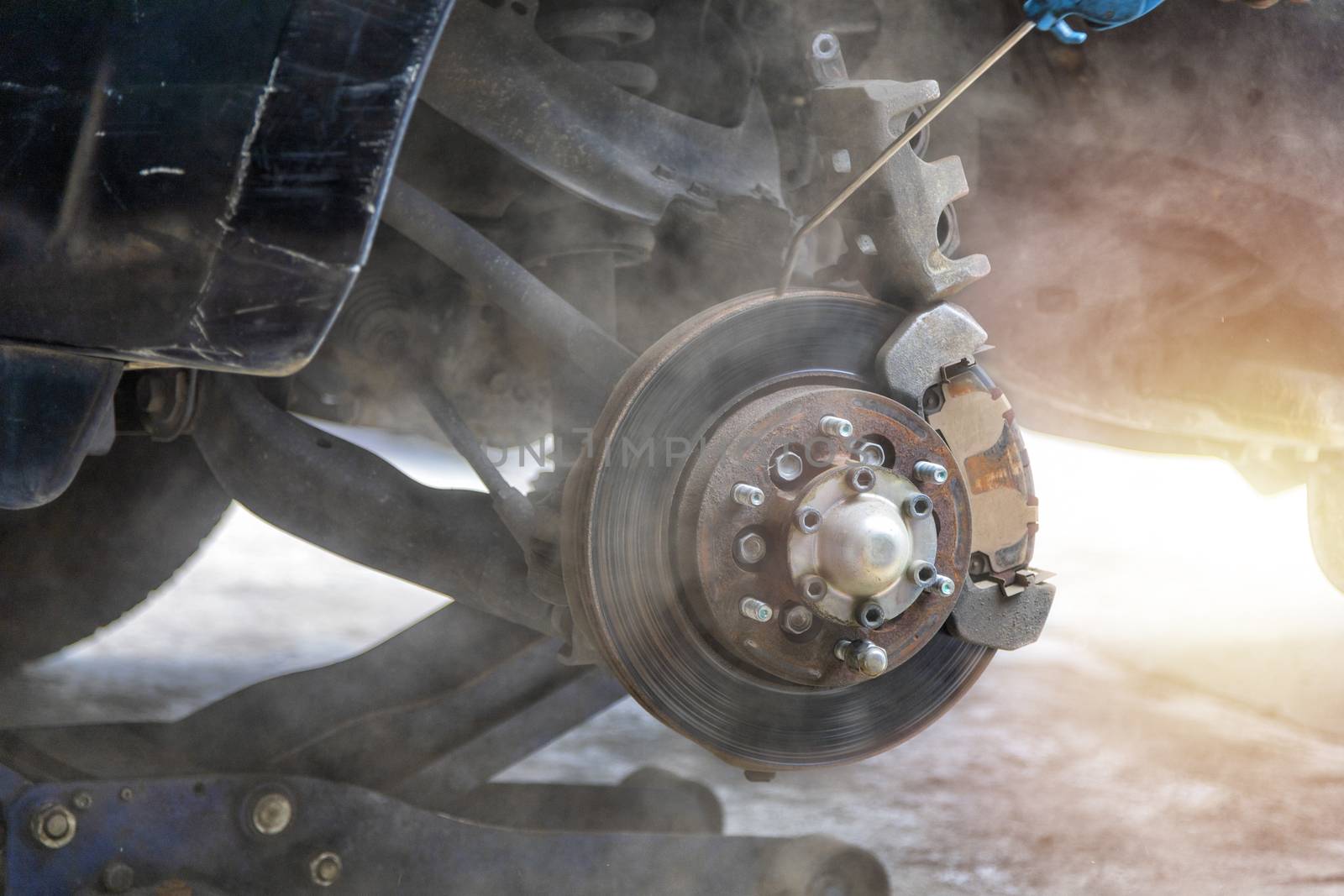 Mechanic use air gun clean disc break take dust removes before change break pat.