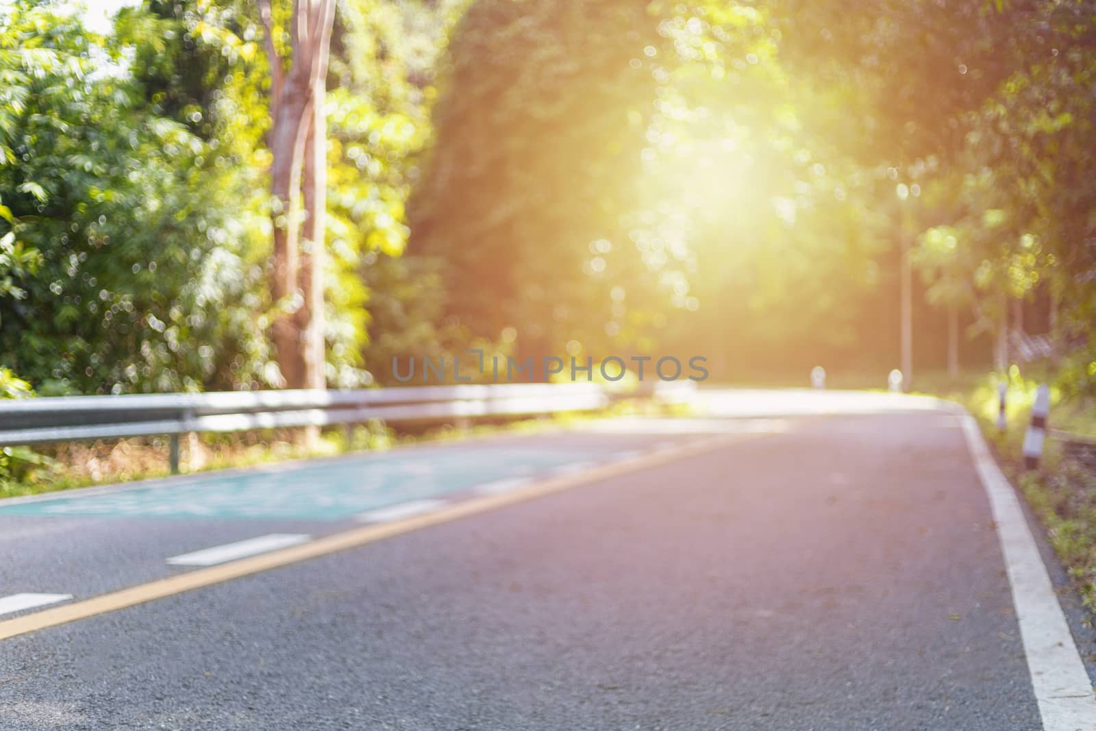 Abstract blurred road and nature background with bright sunlight. With copy space for text or design.