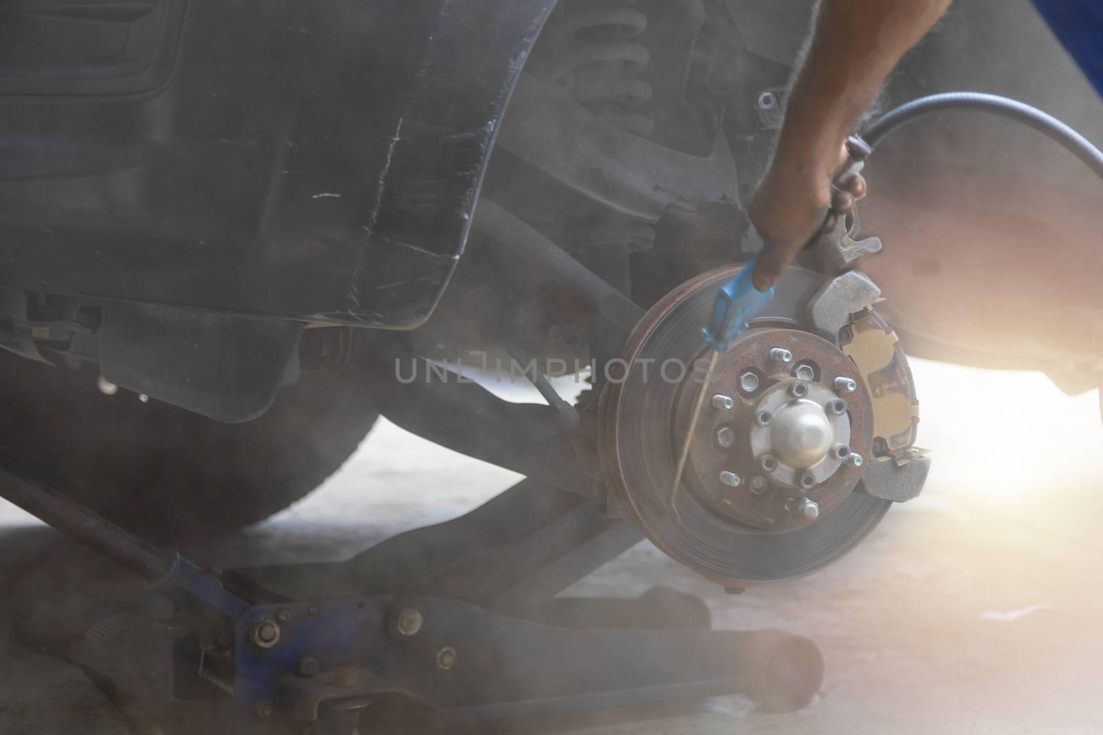 Mechanic use air gun clean disc break take dust removes before change break pat.