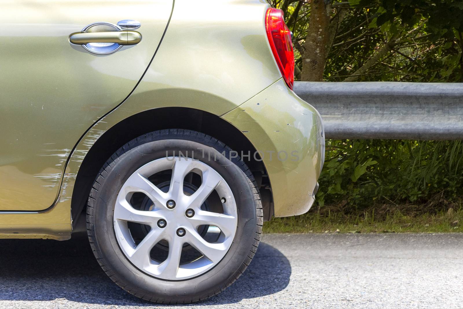 Car crash. Beside the deep green color car have scratch from damage on road. Close up scratch