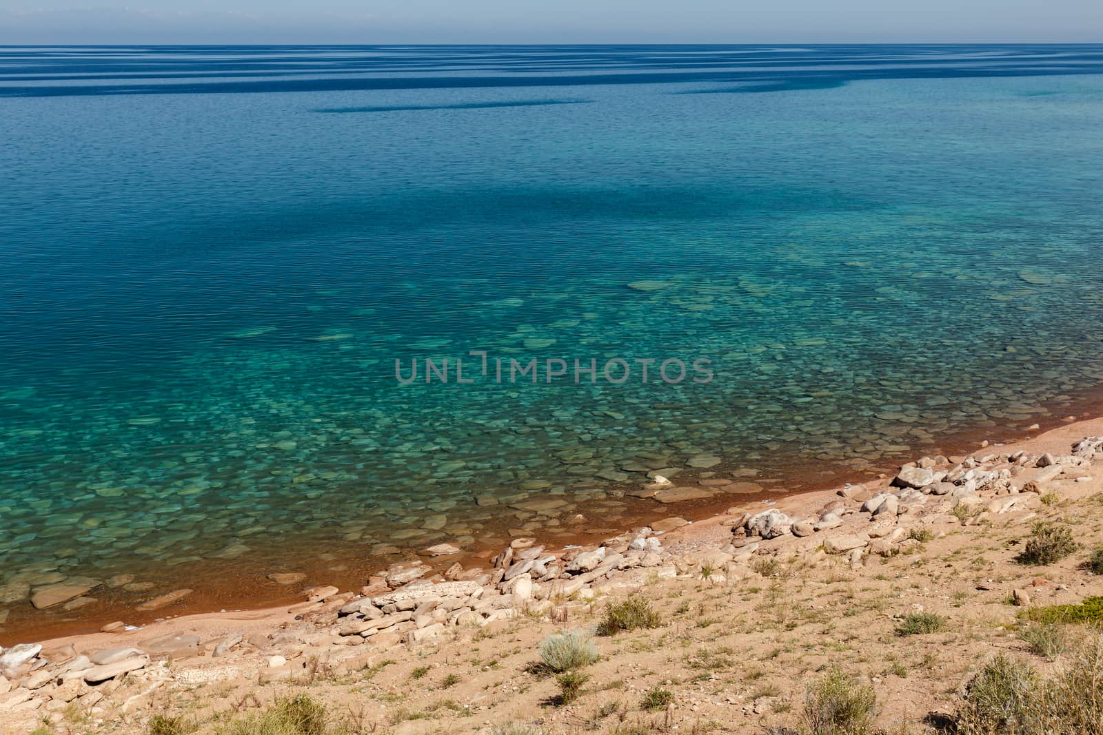 clear water in Issyk-Kul Lake in Kyrgyzstan, stones under water at the bottom.