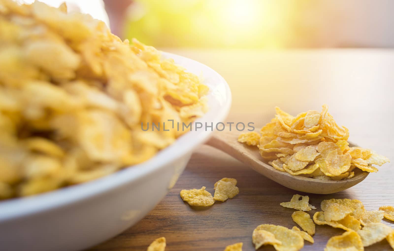 Corn flakes and bowl on wood table