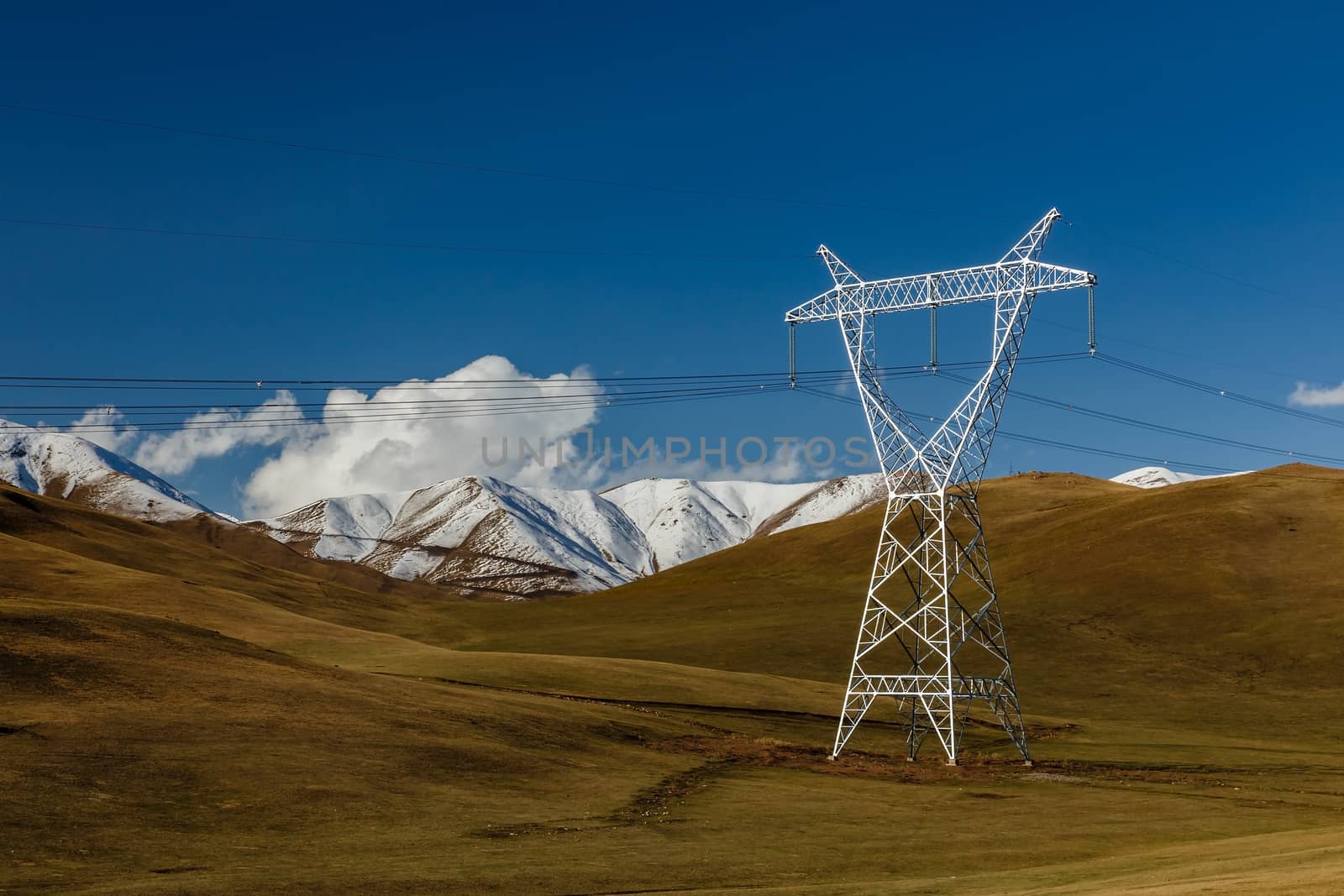 High voltage power line in Kyrgyzstan. Voltage electricity pylon in the mountains.