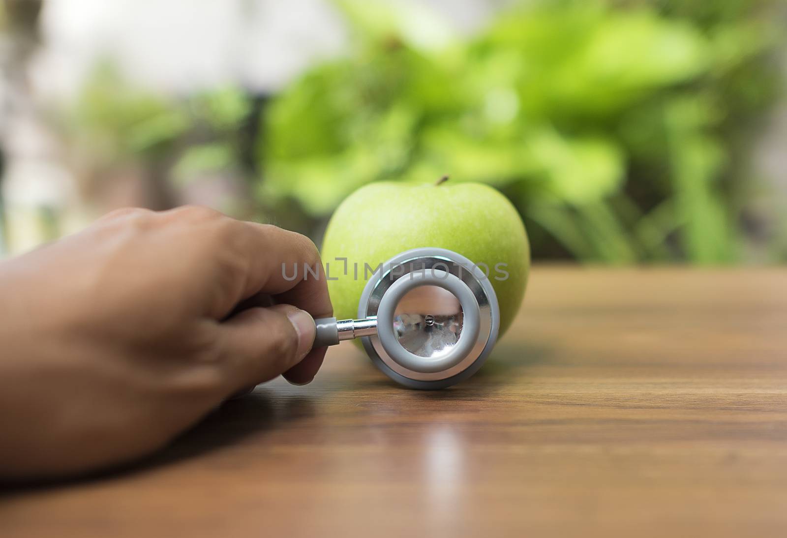 Green apple with stethoscope for health concept