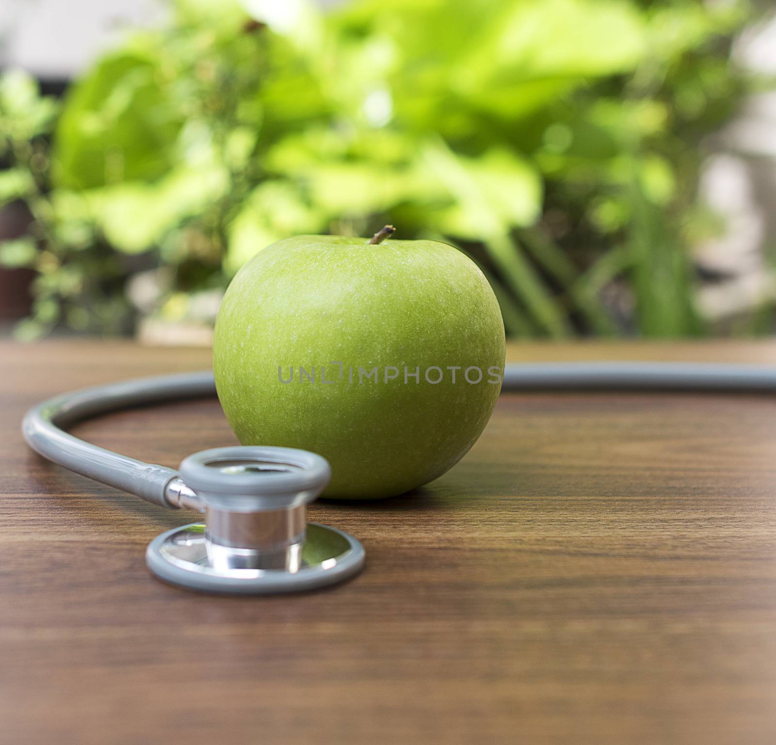 Green apple with stethoscope for health concept