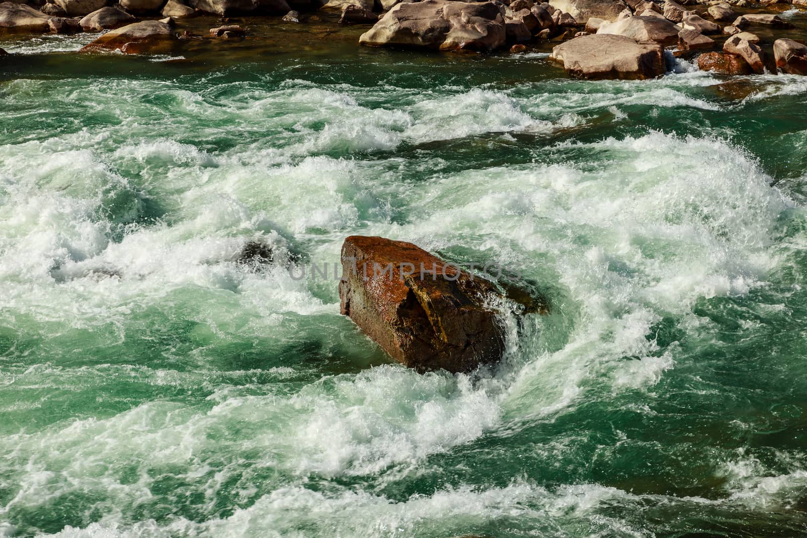 a large stone lies in the middle of a mountain river by Mieszko9