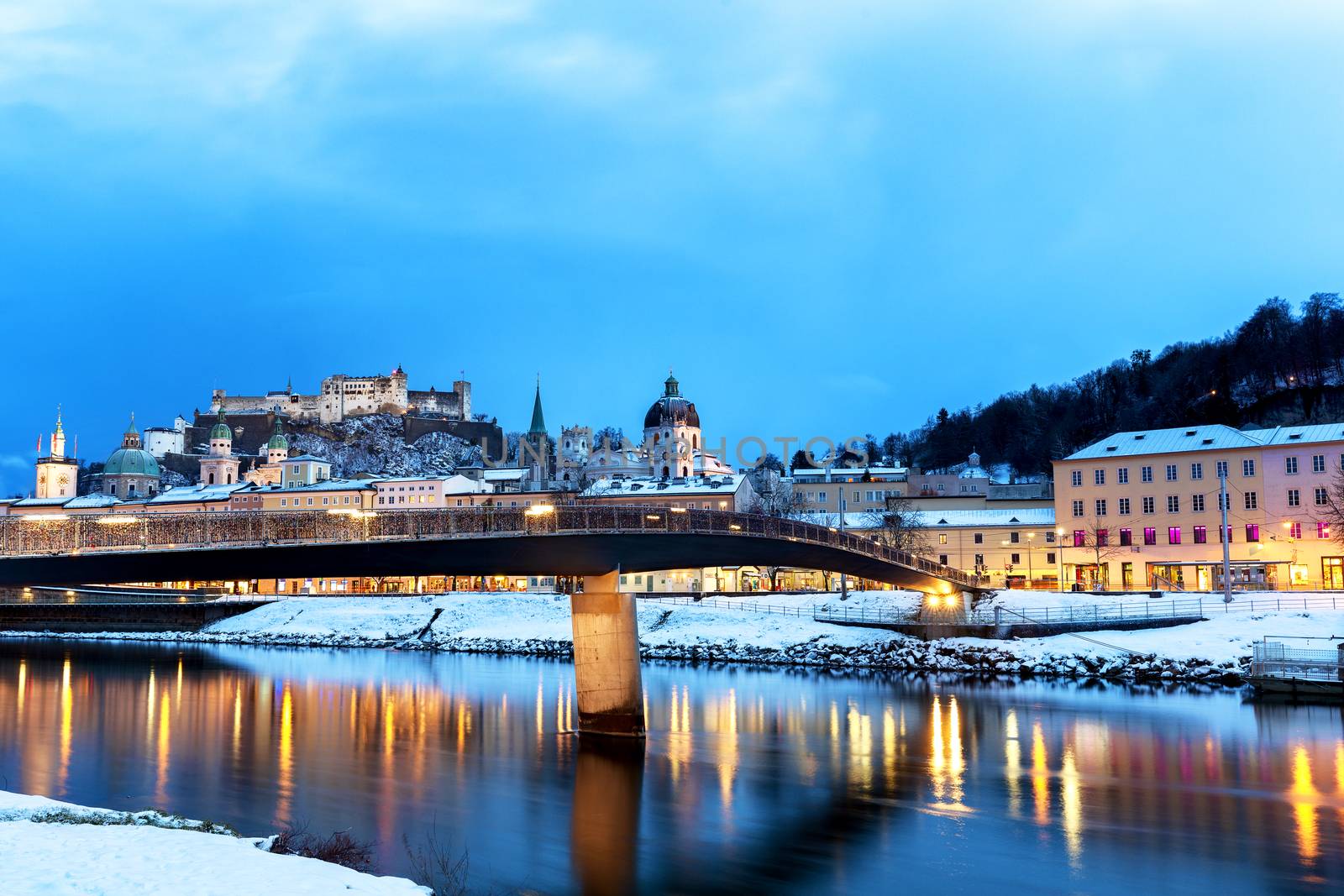 Beautiful view of the historic city of Salzburg with Salzach river in winter during blue hour, Salzburger Land, Austria