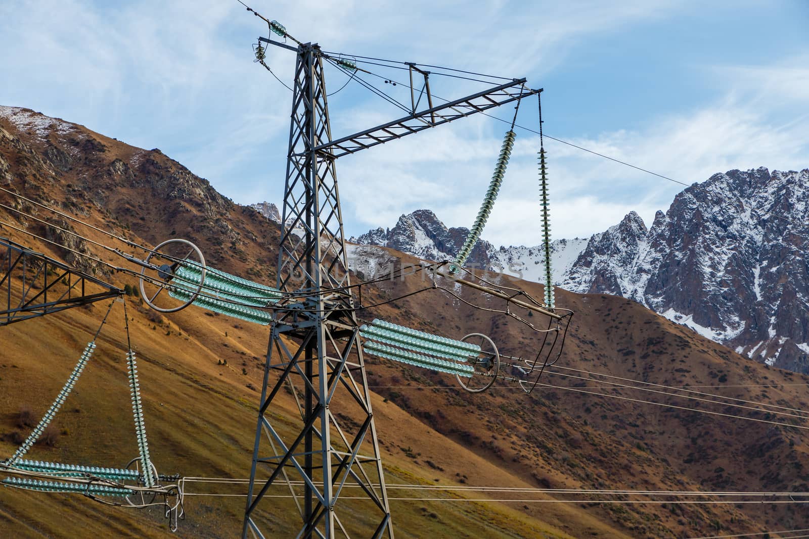 High-voltage electrical insulator electric line against the blue sky and mountains