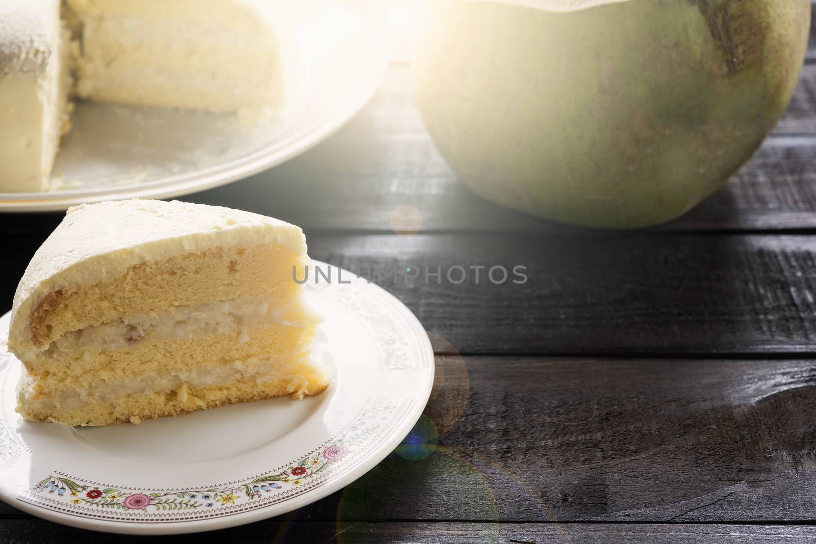 Coconut cream cake with coconut fruit on wood bakcground