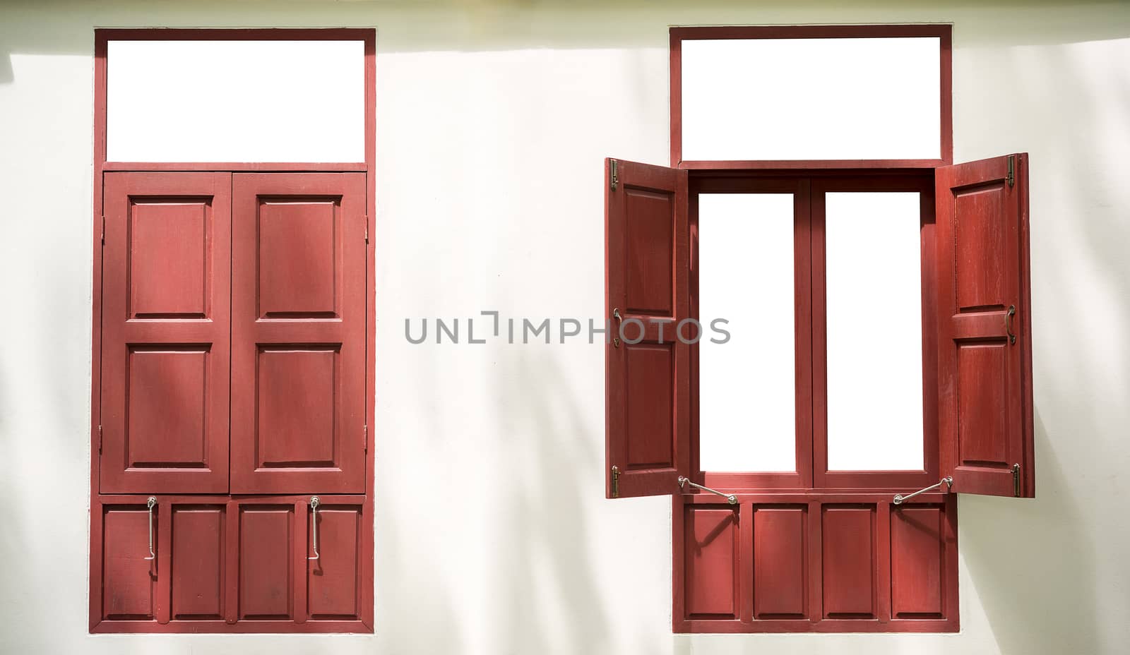 Two red wood twin windows one open one close on white wall background