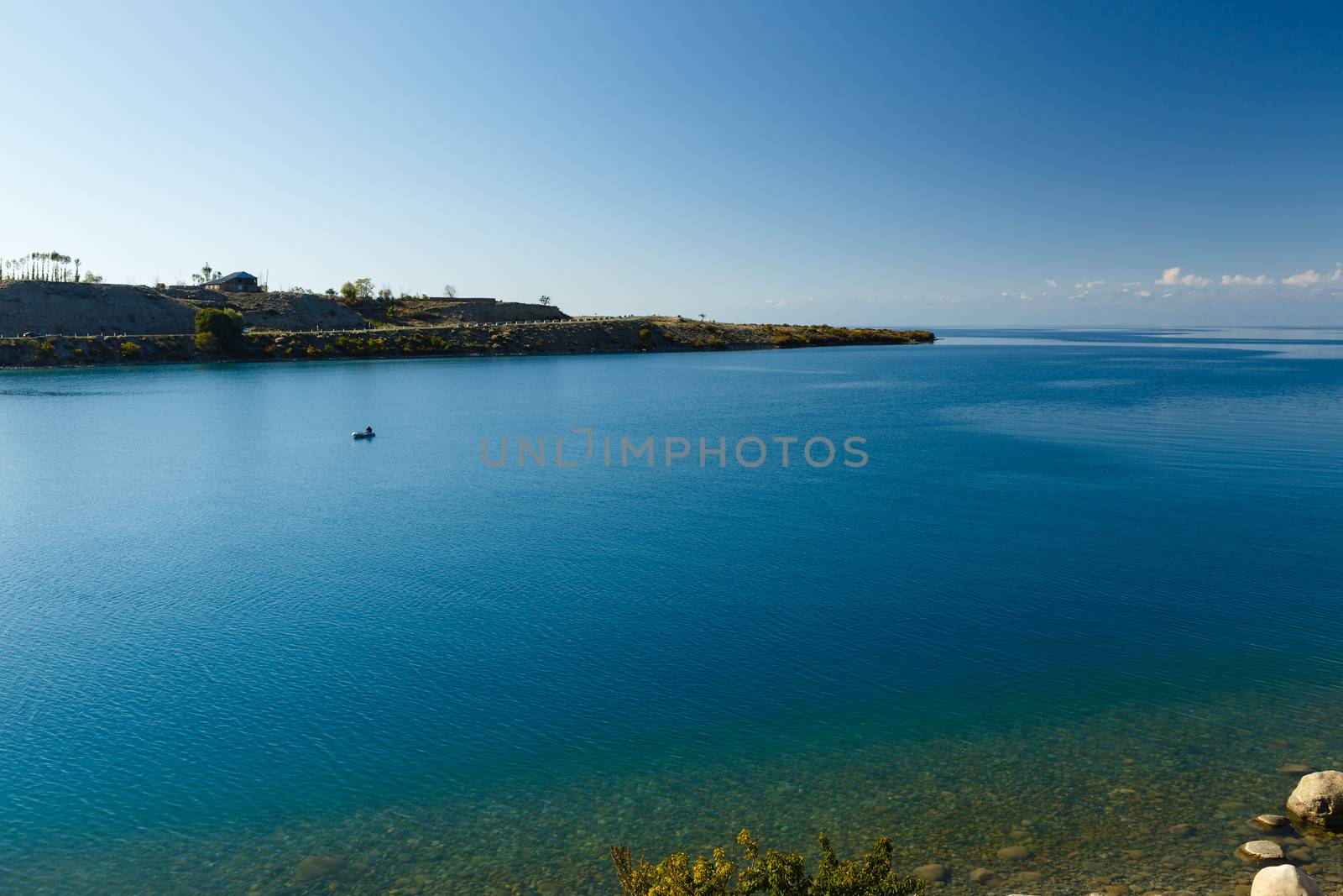 South shore of Issyk-kul lake in Kyrgyzstan, fisherman on a boat on Issyk-Kul Lake