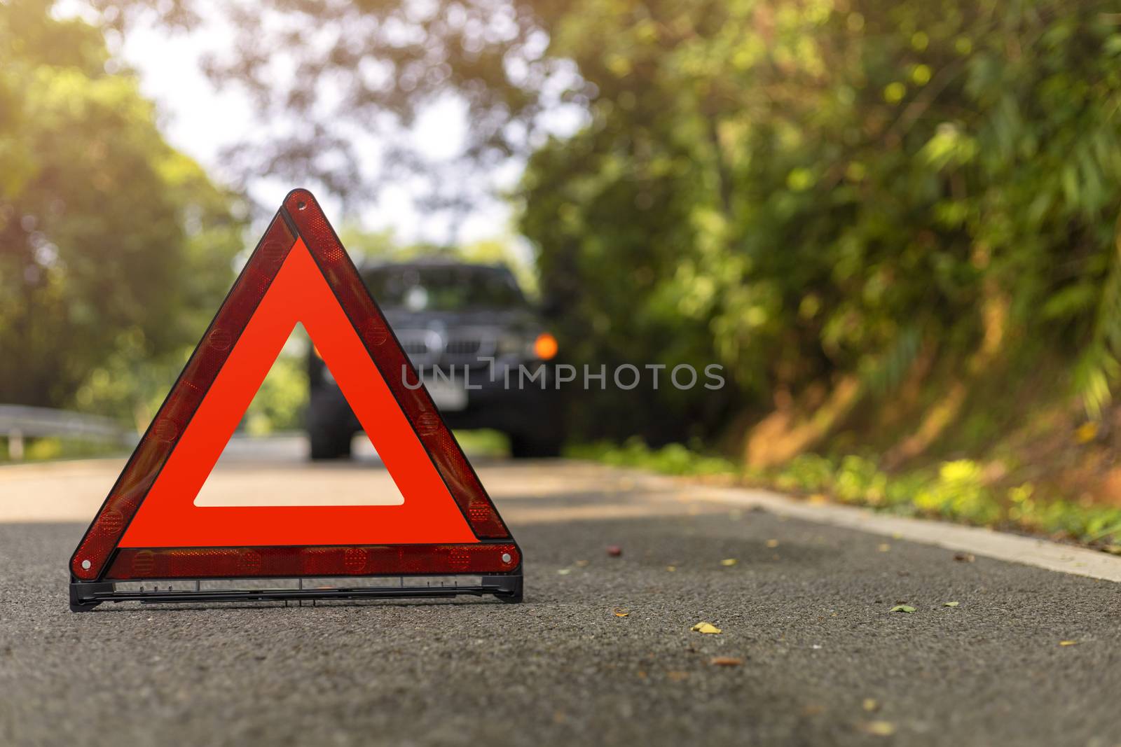 Red triangle, red emergency stop sign, red emergency symbol and black car stop and park on road.