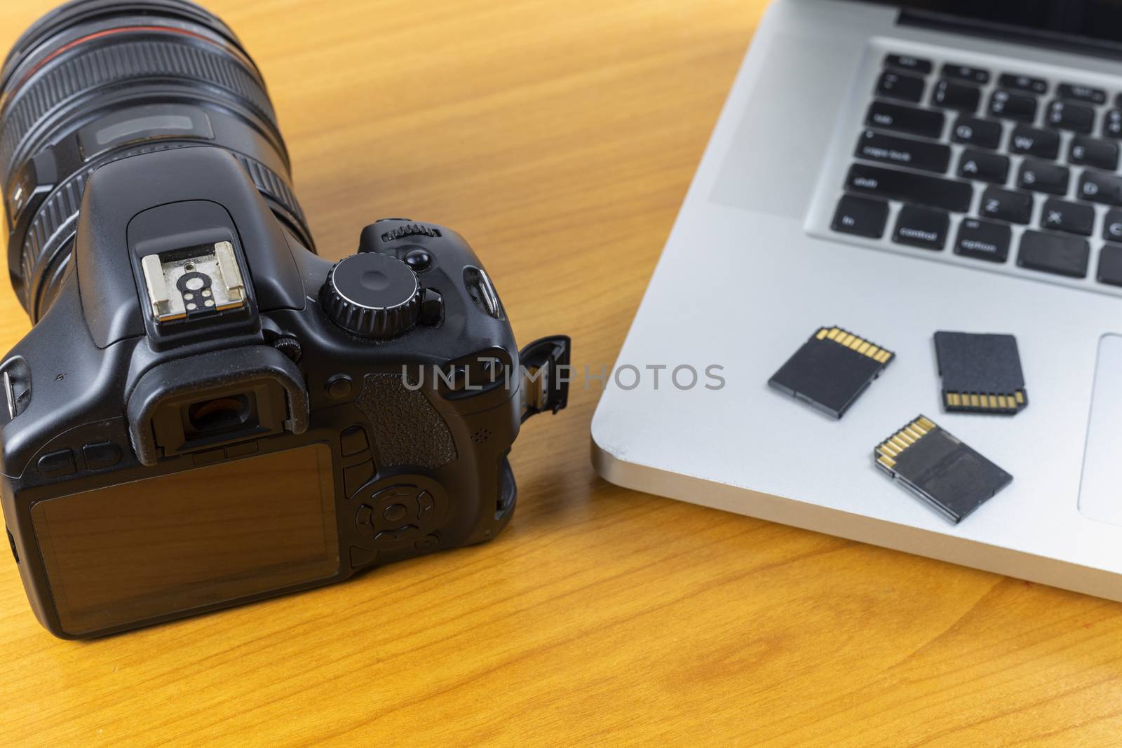 Digital camera, Laptop and memory card on wood table. With copy space for text or design.