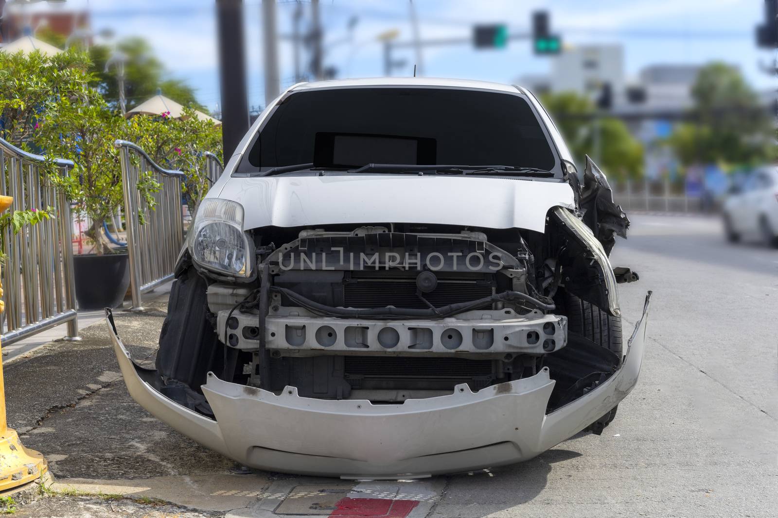 Front of white color car big damaged and broken by accident on city street parking can not drive any more. With copy space for text or design