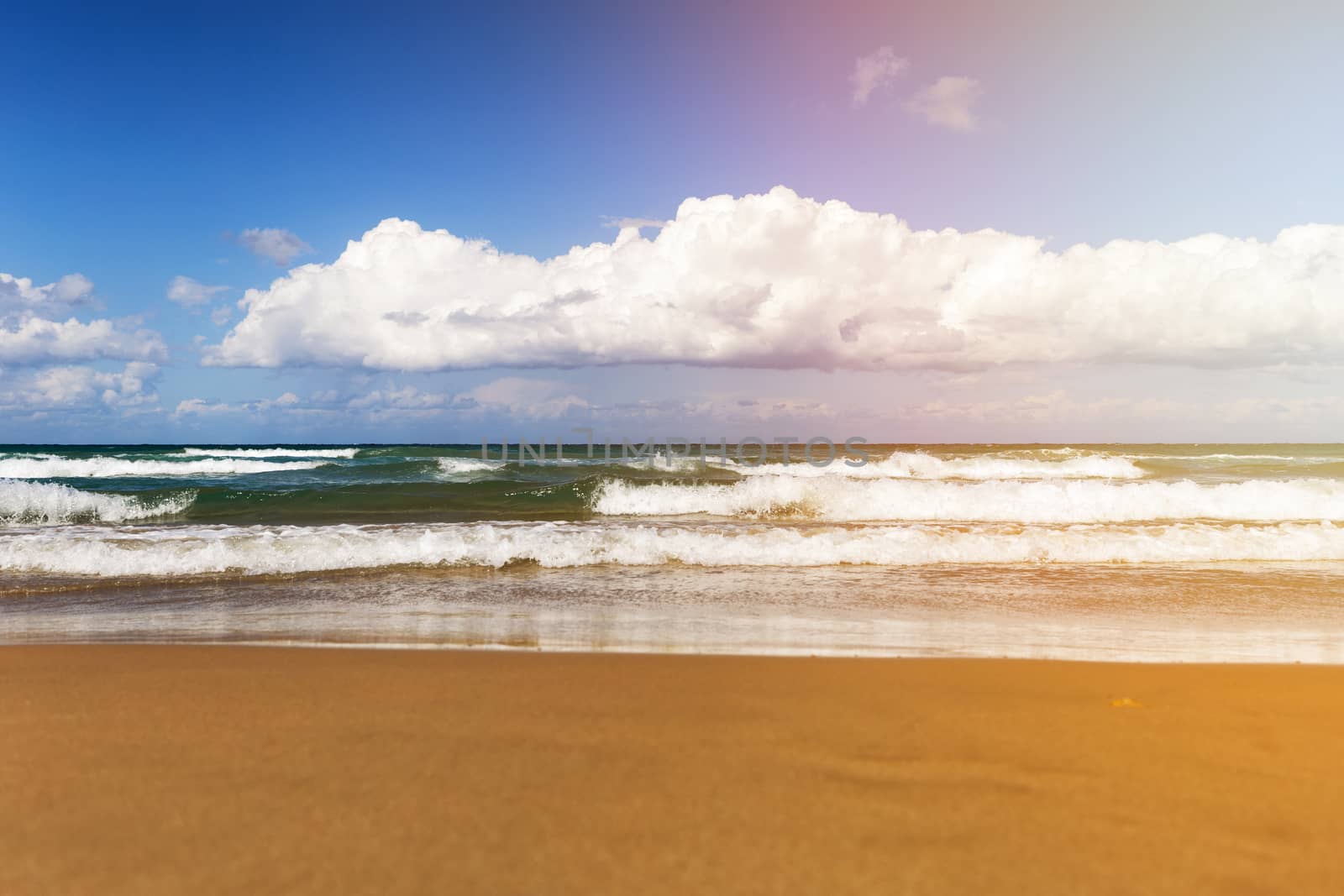 Sunny day on the beach with big waves and white clouds by necro79