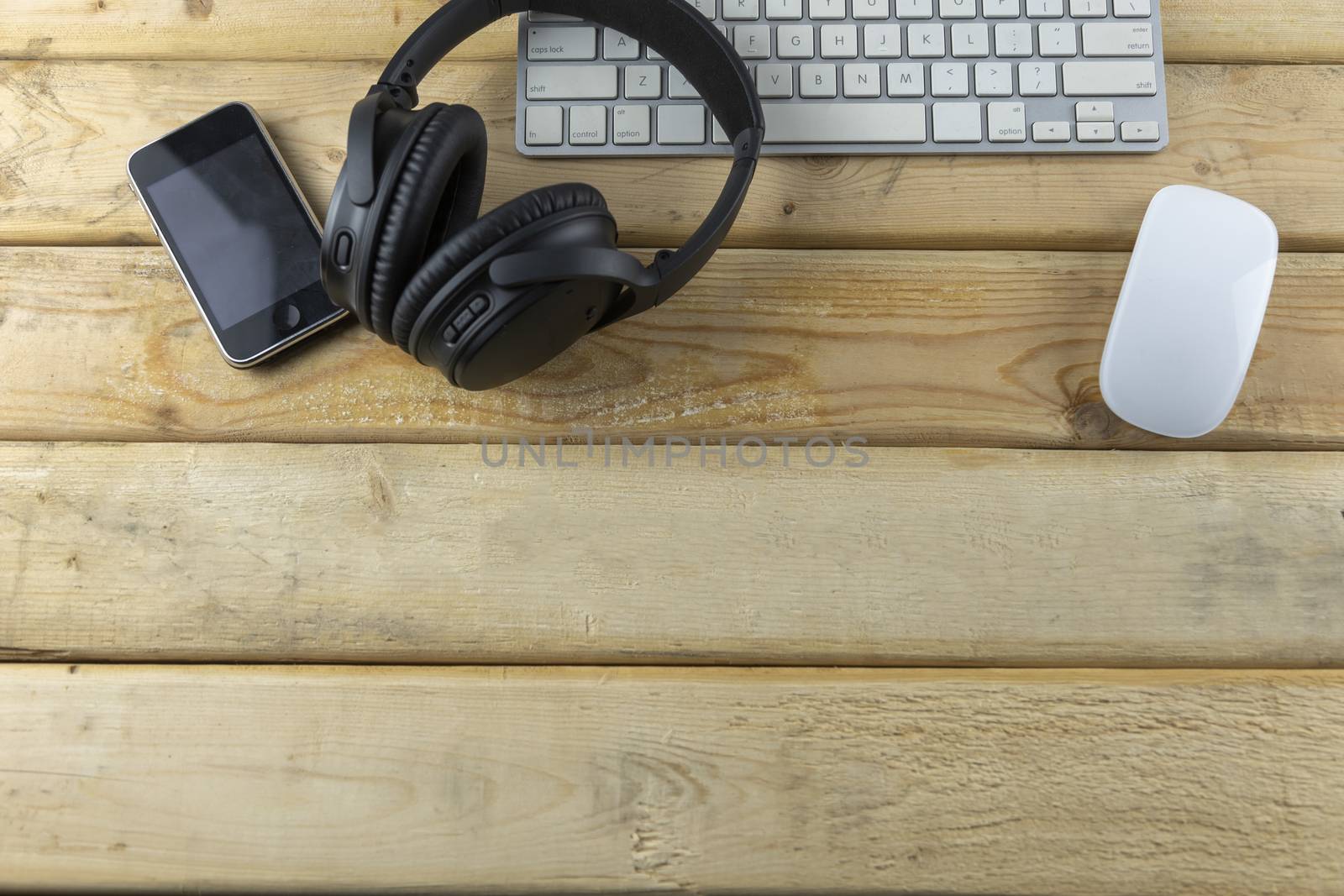 Headphone, Keybord, Mouse and music portable on wood table with copy space for text or design.
