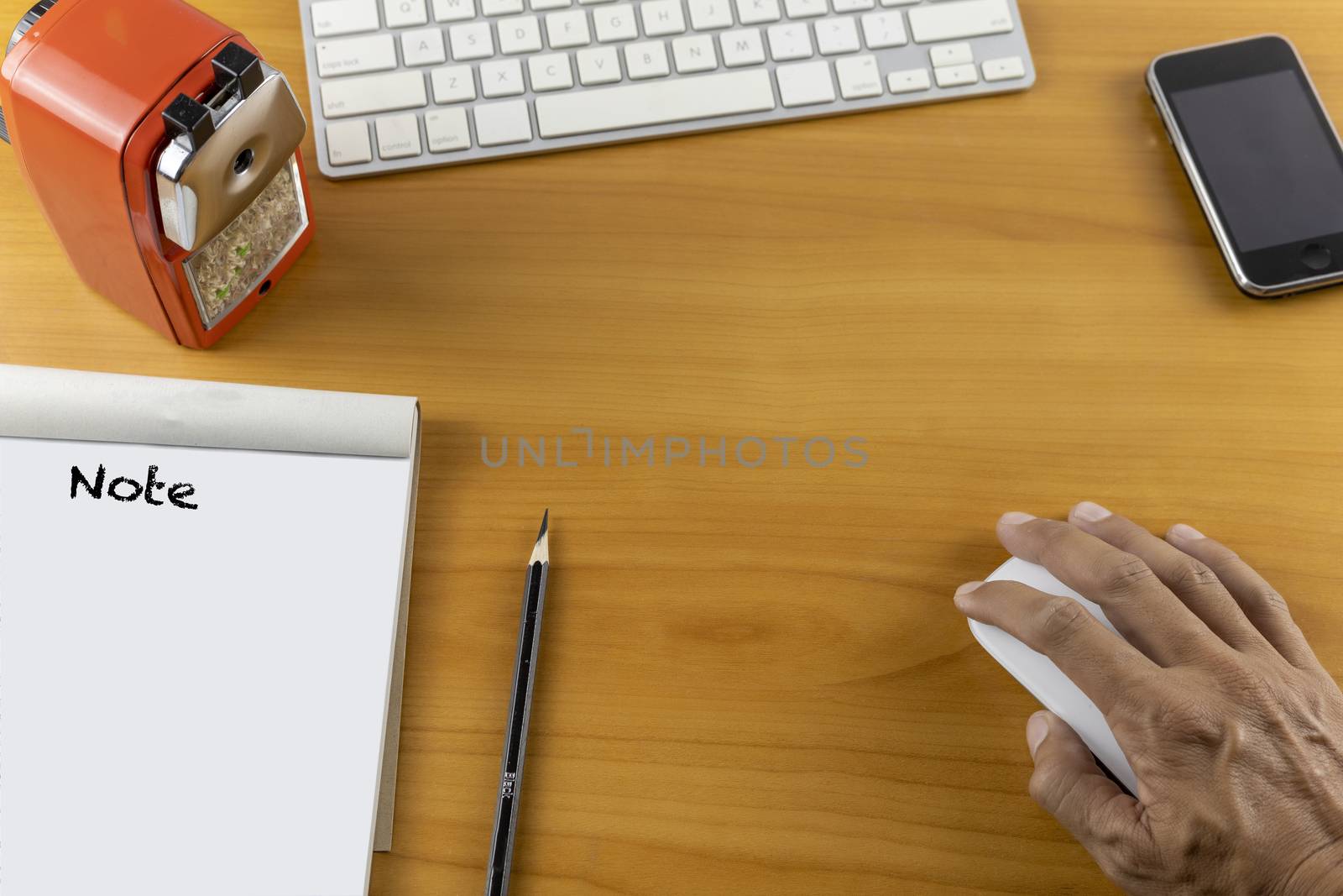 Top view office desk with mouse, laptop, keyboard, bill book, pencil sharpener and pencil on wood table . With copy space for text or design.