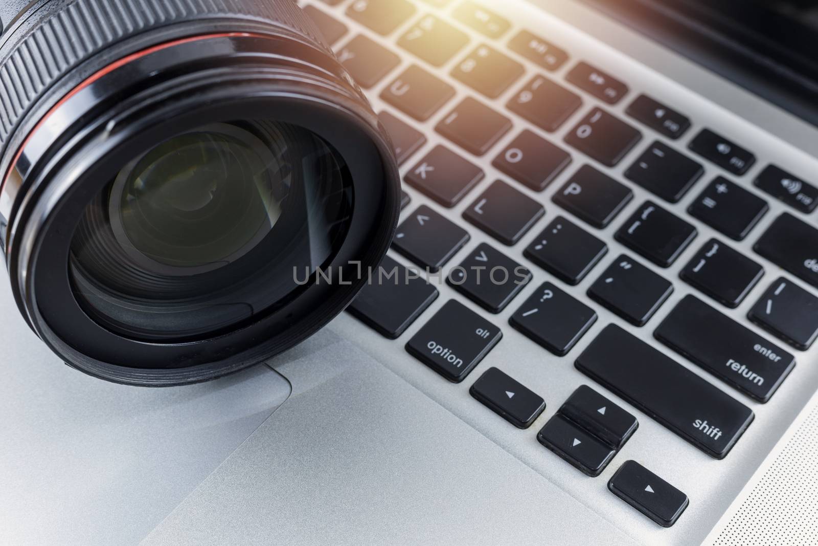 Close up Digital camera len on laptop. Photographic concept